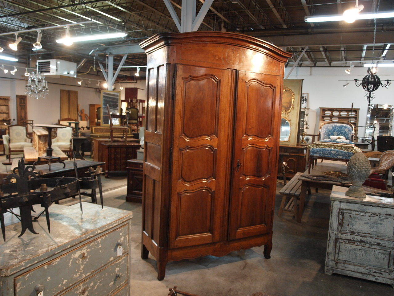 A stately late 18th century French Louis XV armoire in walnut. This very handsome armoire has touches of marquetry detailing to the front, above and below the door panels. The patina is very rich and luminous with wonderful grain patterns. A
