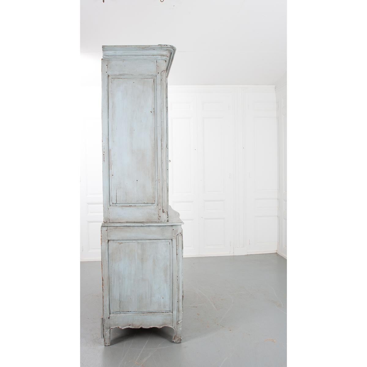 This large piece is a French 18th century buffet a deux corps. It has its original, worn, soft blue/gray painted finish. Incredible patina. The base is 40-?”H. It has one stationary shelf on the bottom that is 22-¾” D. The base has one key and a