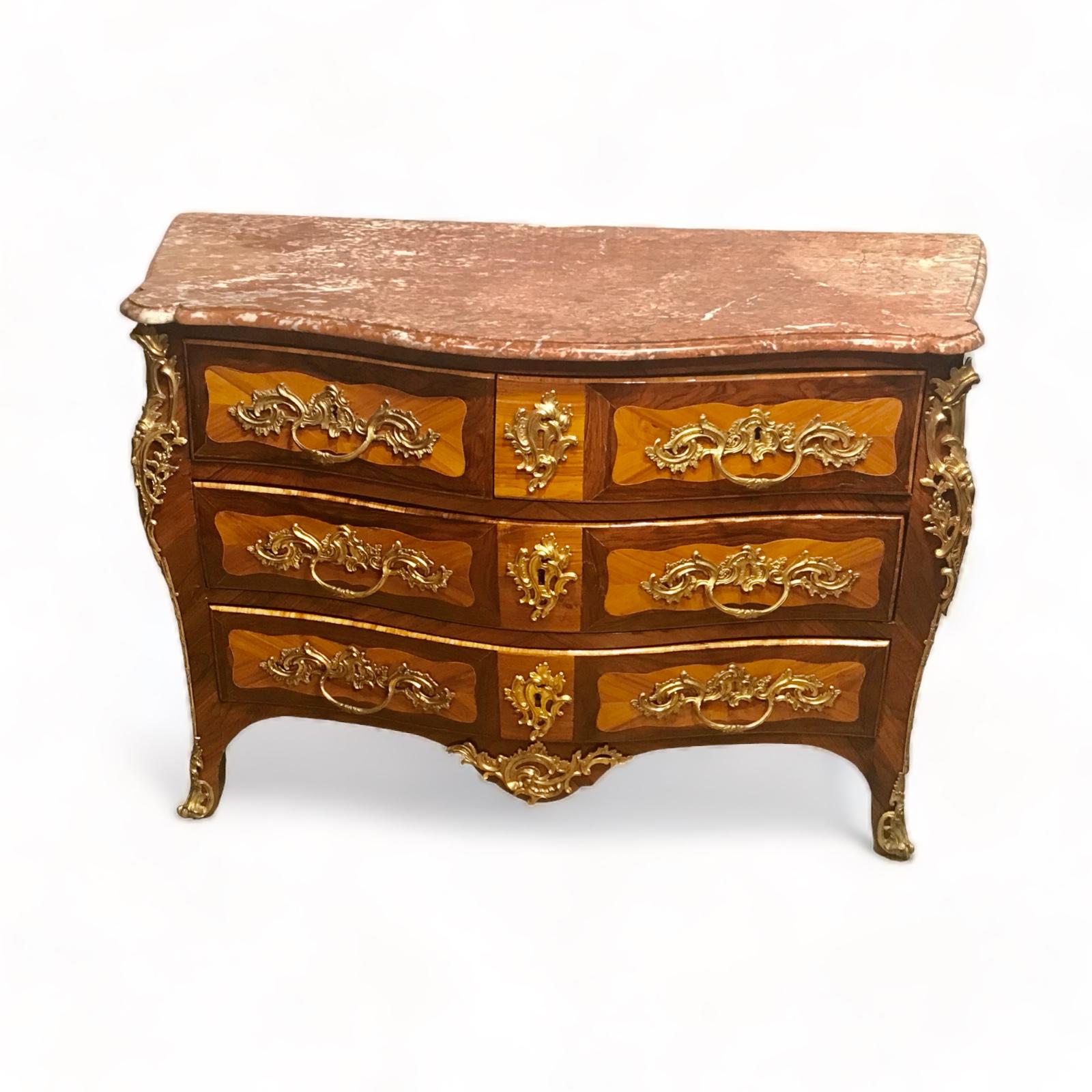 Indulge in the timeless allure of this exquisite 18th century  French Louis XV Bombe Commode, a true embodiment of opulence and sophistication. Elevated on gracefully curved legs adorned with scrolled caps, this fine piece showcases a bombé front
