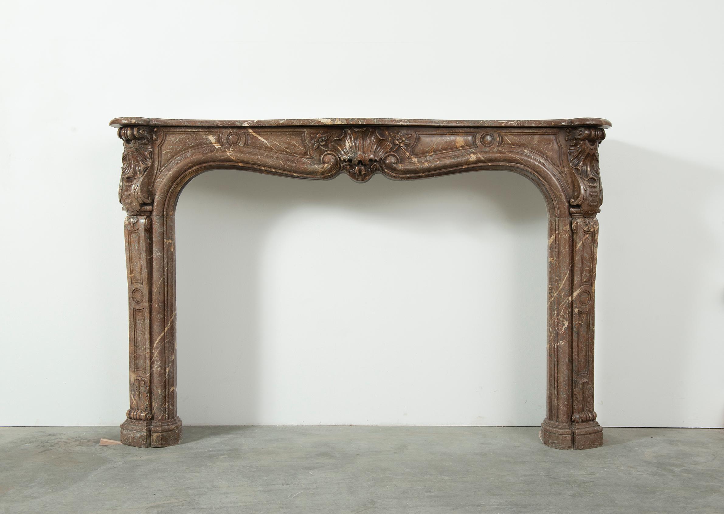 French 18th Century Louis XV Fireplace mantel in red marble 

A very attractive and well-proportioned French Louis XV fireplace, in Belgian red marble.
Beautifully carved central cartouche between to S-scrolled endblocks descending on shaped and