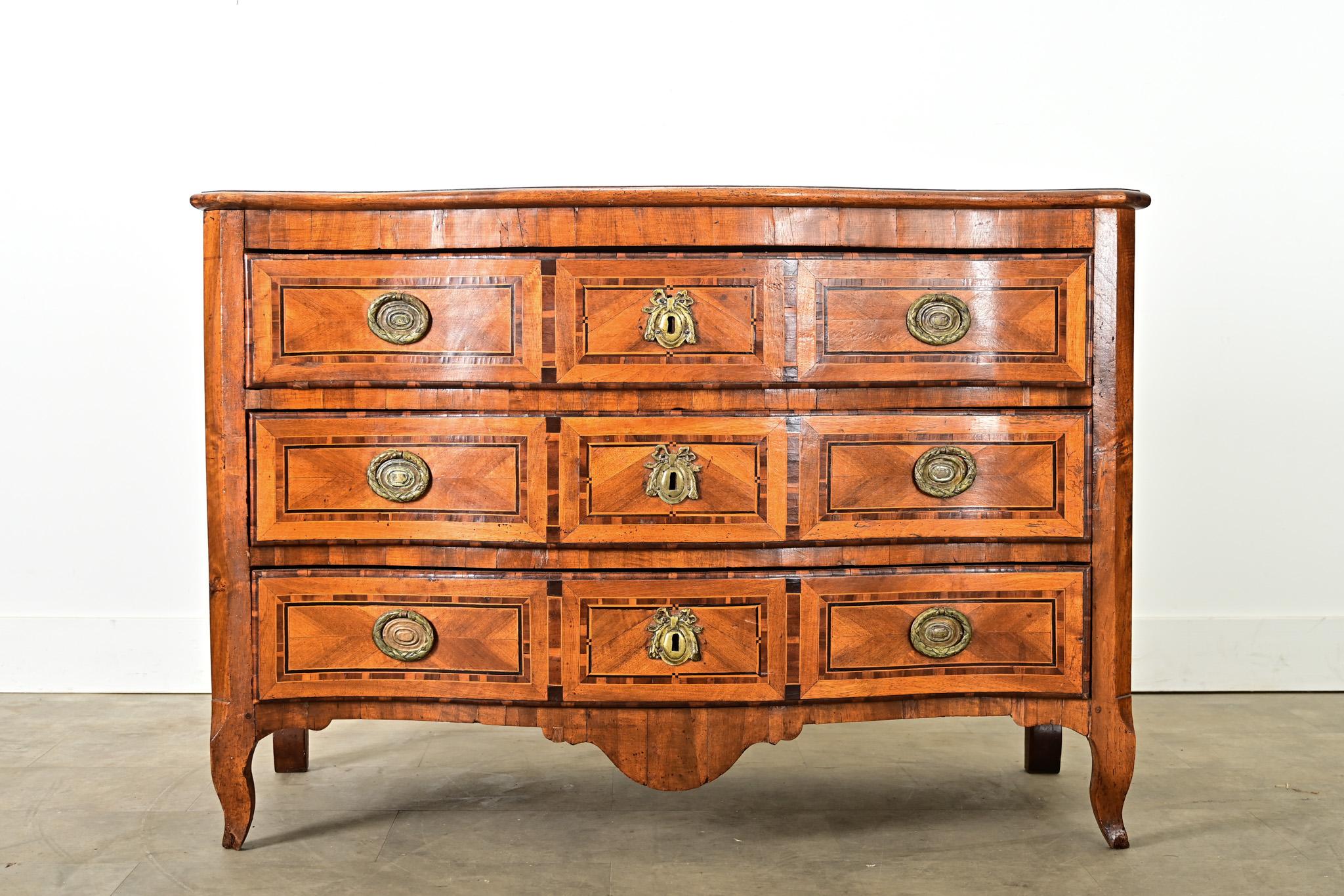 Una straordinaria commode francese del XVIII secolo, in stile Luigi XV, decorata con impressionanti tecniche di intarsio che creano movimento e definizione sul piano e sui cassetti. La superficie della commode è intarsiata con un motivo geometrico