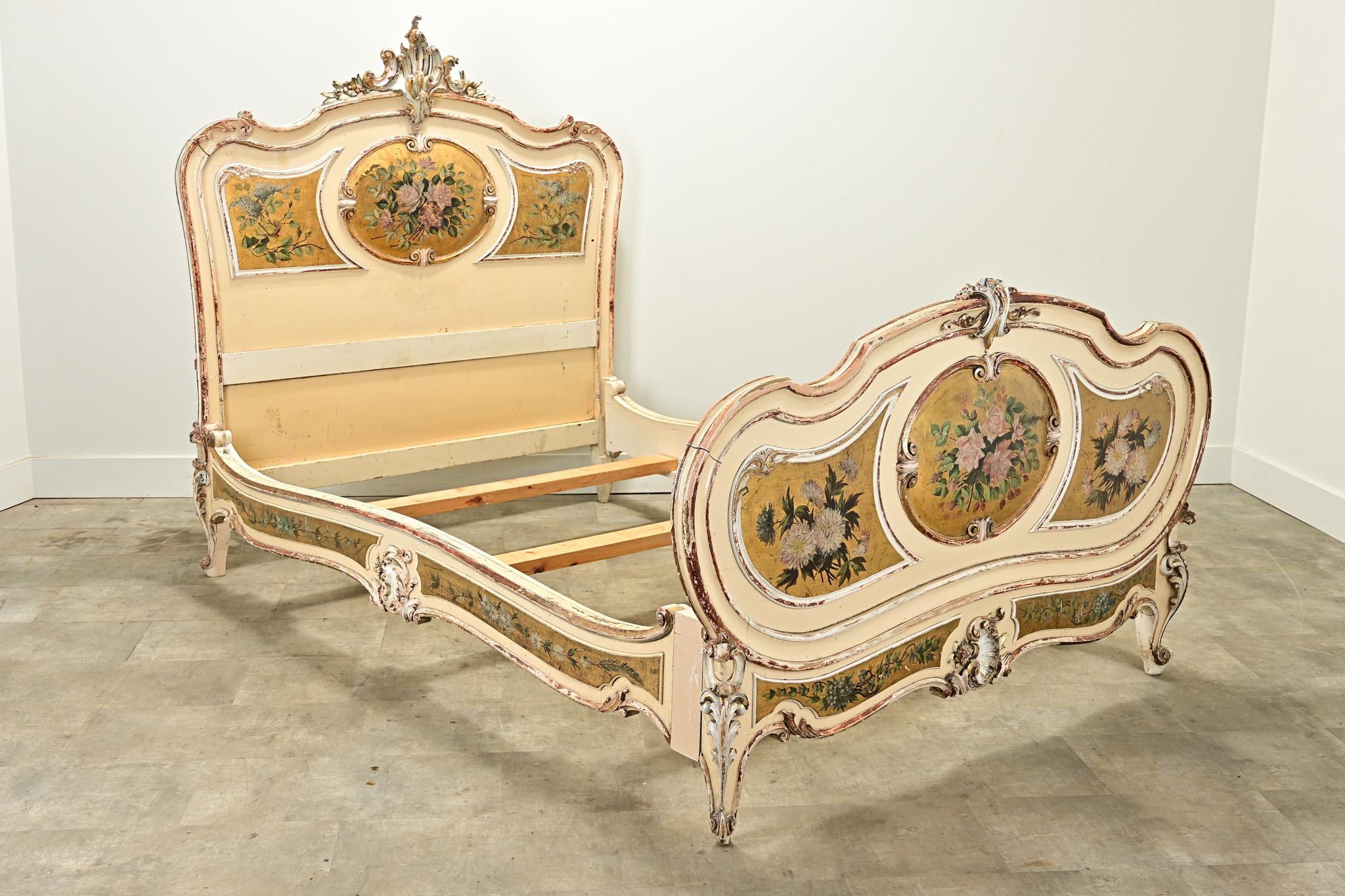 A quality Louis XV Period carved and gold gilt queen bed frame. The four piece frame has classic carvings of Rococo influenced Louis XV style with flamboyant carvings and gold gilt cartouches with hand painted flowers. The bedrails have been
