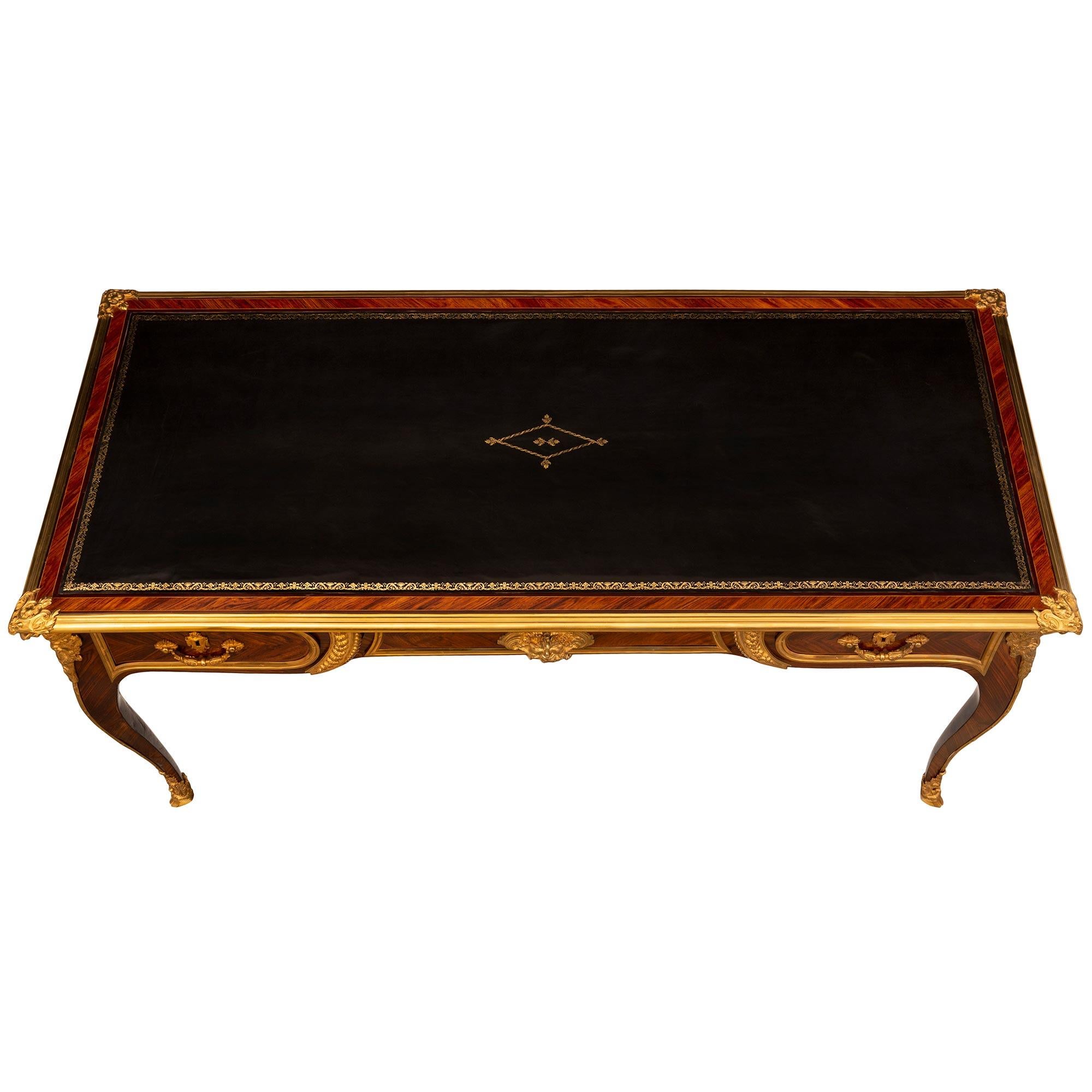 A magnificent and very high quality French 18th century Louis XV period Tulipwood, Kingwood, and ormolu Bureau Plat desk. The desk is raised by elegant cabriole leg with exquisite pierced fitted ormolu sabots with fine foliate designs and hoof feet