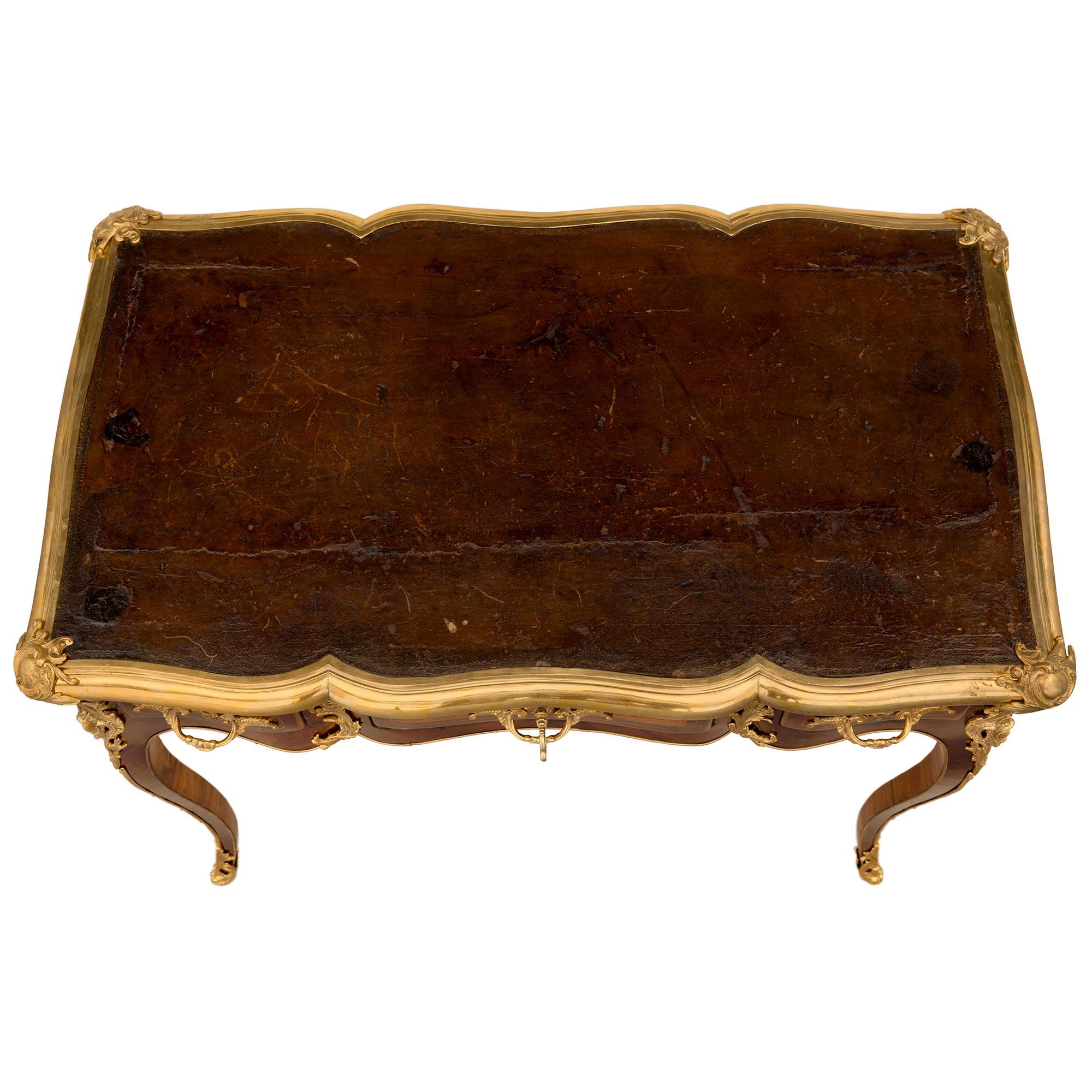 Un bureau d'époque Louis XV du 18ème siècle de très haute qualité, en bois de roi, tulipier et bronze doré, signé 'Bernard Ebeniste'. Ce bureau des plus élégants est surélevé par de minces pieds cabriole avec des sabots feuillagés finement percés et