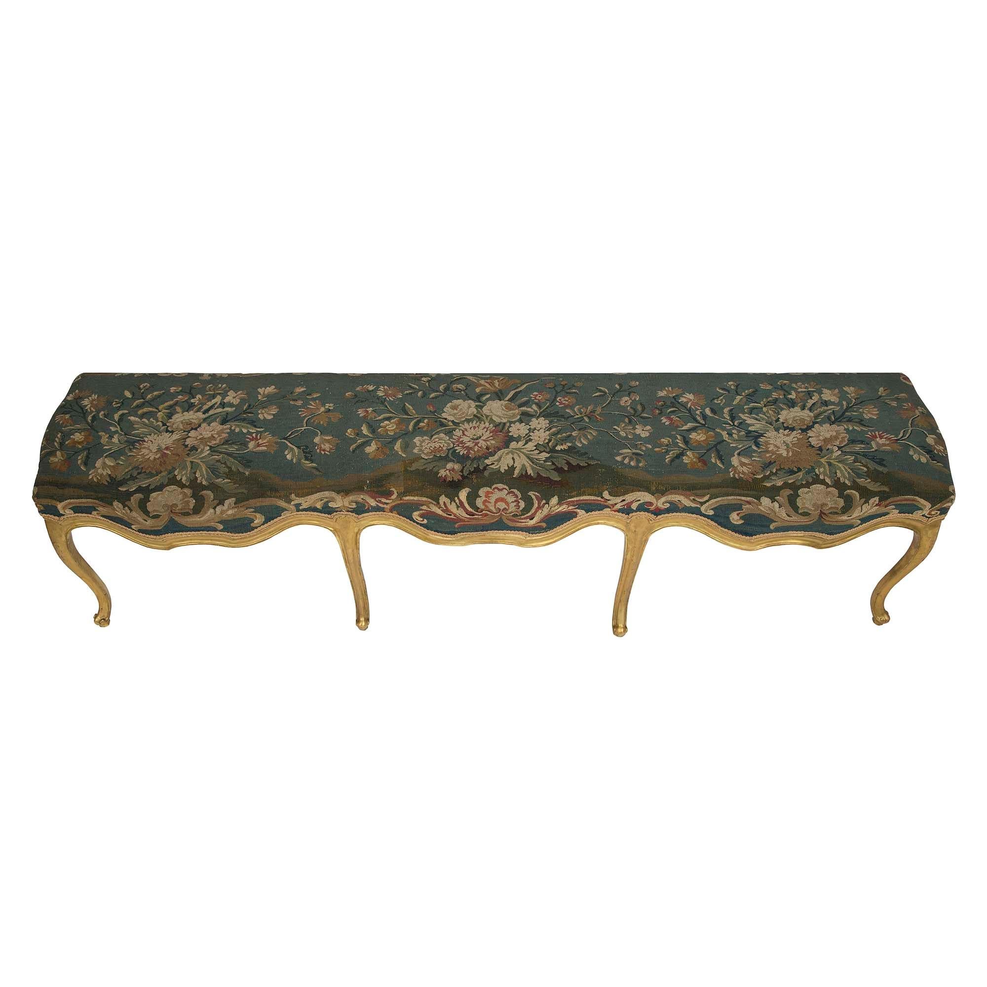 Très attrayant et inhabituellement large banc à huit pieds en bois doré et tapisserie d'Aubusson d'époque Louis XV du XVIIIe siècle. Le banc est élégamment surélevé par des pieds cabriole allongés à volutes en 