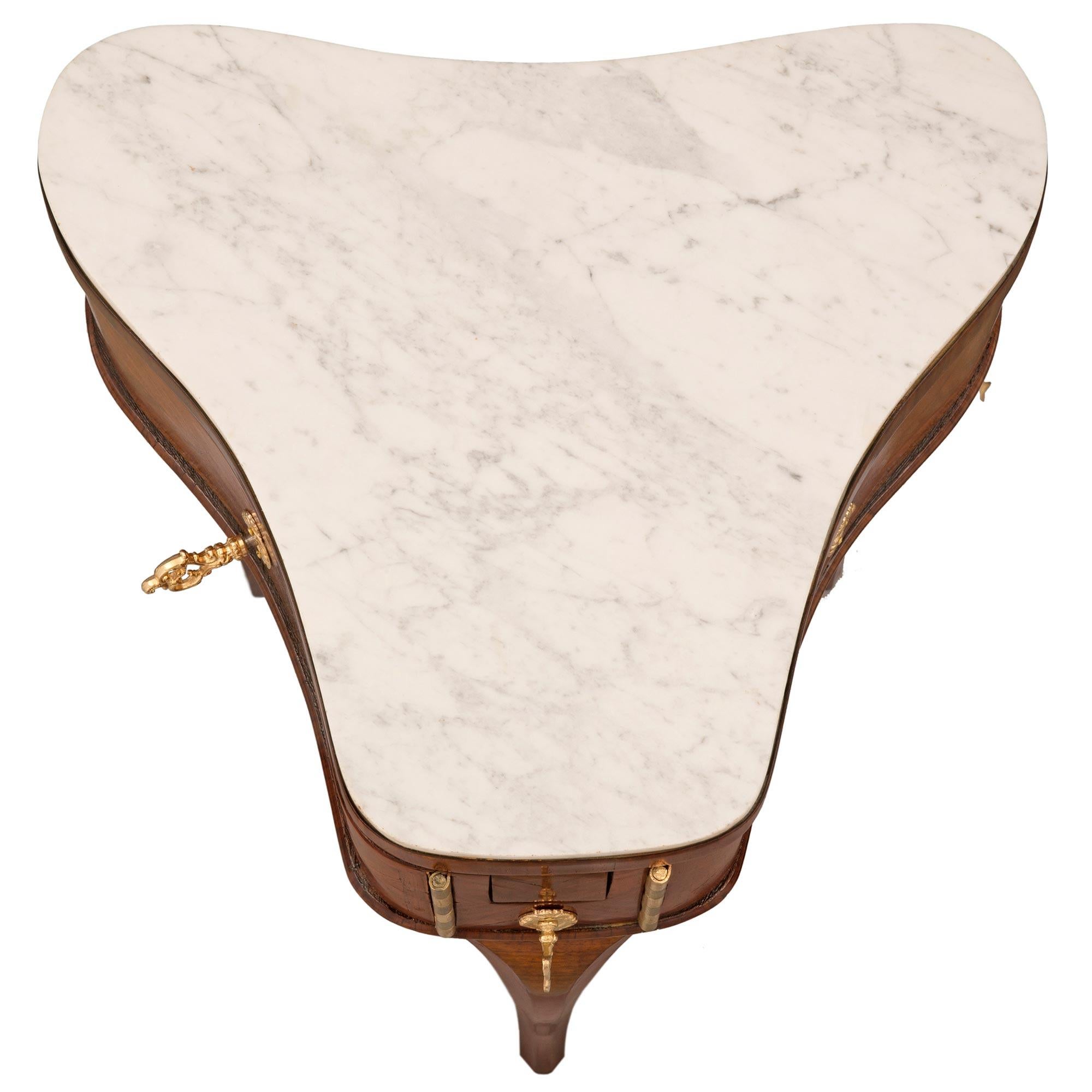 A unique and extremely decorative French 18th century Louis XV period kingwood and white Carrara marble side table. The clover shaped table is raised by three elegant tapered cabriole legs with most decorative cut designs at the front. The apron