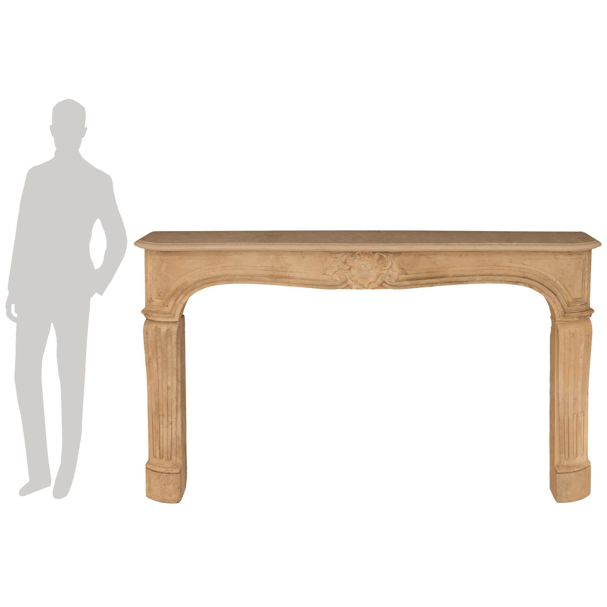 A wonderful and most impressive French 18th century Louis XV Period Limestone fireplace mantel. This wonderful mantel is raised by elegant jambs each displaying fine recessed mottled and fluted designs. The gently curved frieze displays attractive