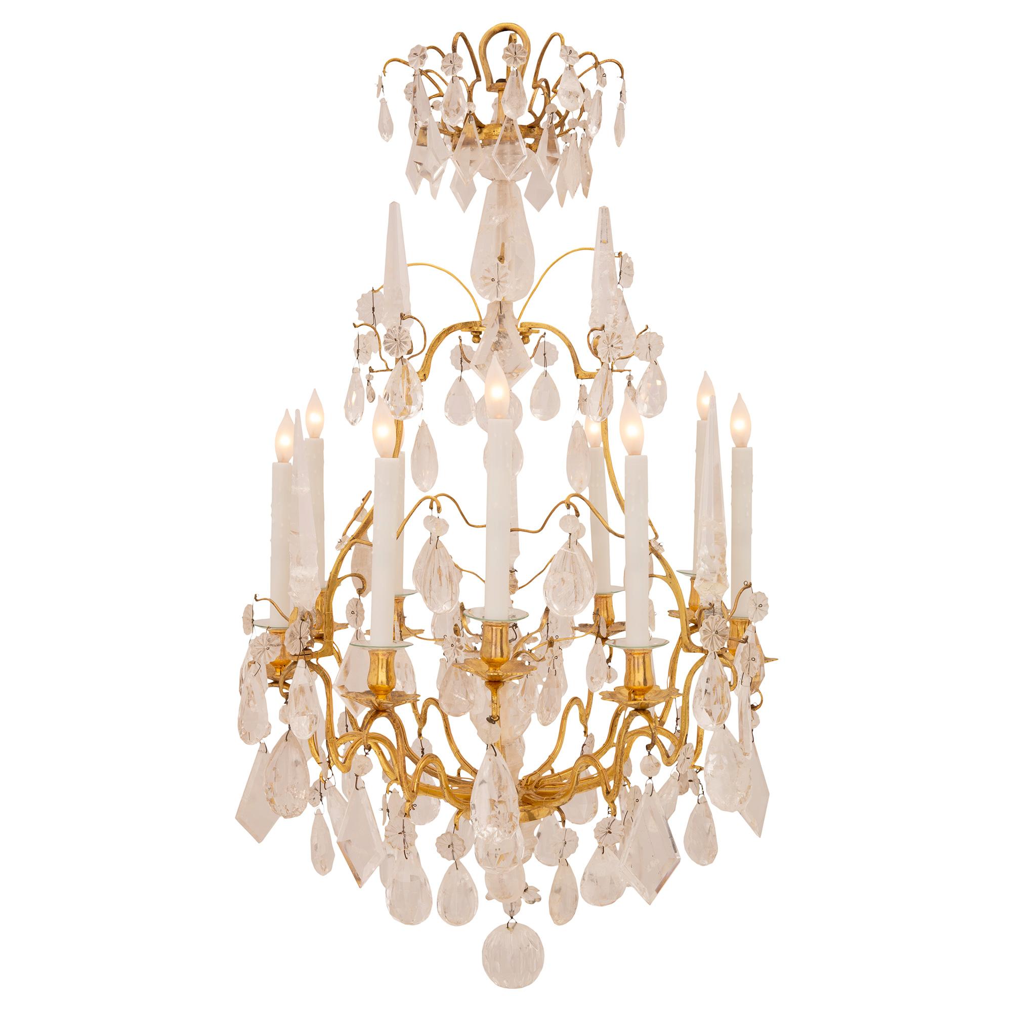 A stunning French 18th century Louis XV period ormolu and rock crystal chandelier. The nine arm chandelier is centered by a beautiful solid rock crystal ball pendant amidst additional superb tear drop shaped pendants. The elegant and most decorative