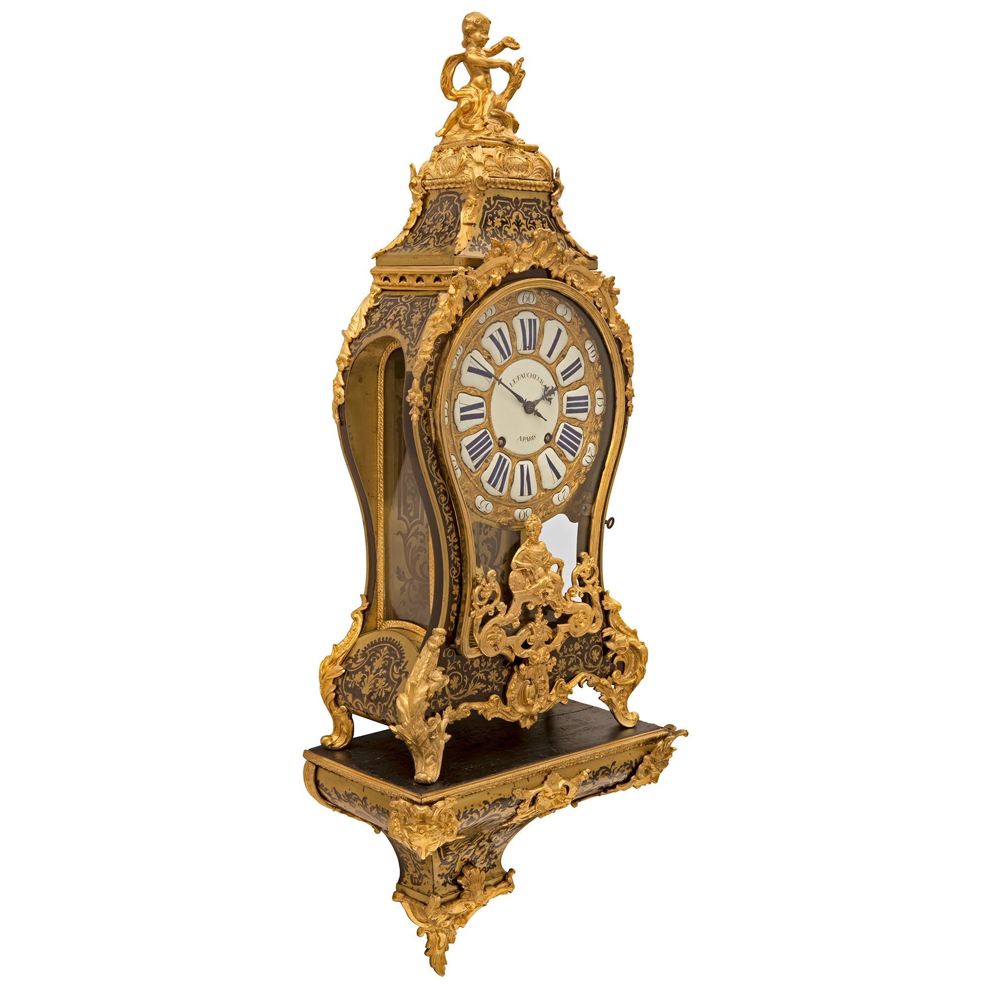 A large and important French 18th century Louis XV period Tortoiseshell and ormolu Boulle cartel clock signed Le Faucheur, A Paris. The clock is raised on its original display shelf with an exceptional curved tapered design with a stunning scrolled