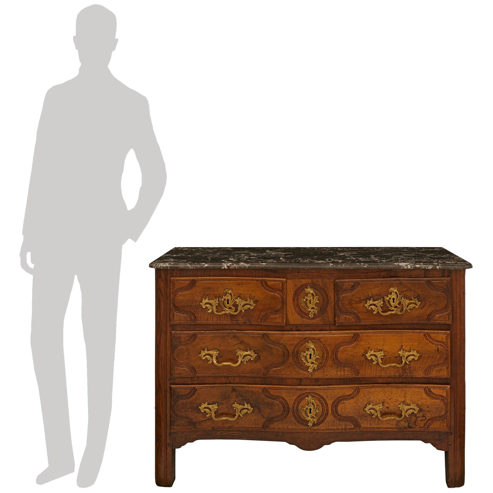 Una bella e decorativa commode in noce e ormeggio del periodo Luigi XV del XVIII secolo. La cassapanca è sollevata su quattro gambe quadrate in noce sotto il grembiule a forma di arbalete. Sopra ci sono cinque cassetti riccamente intagliati e