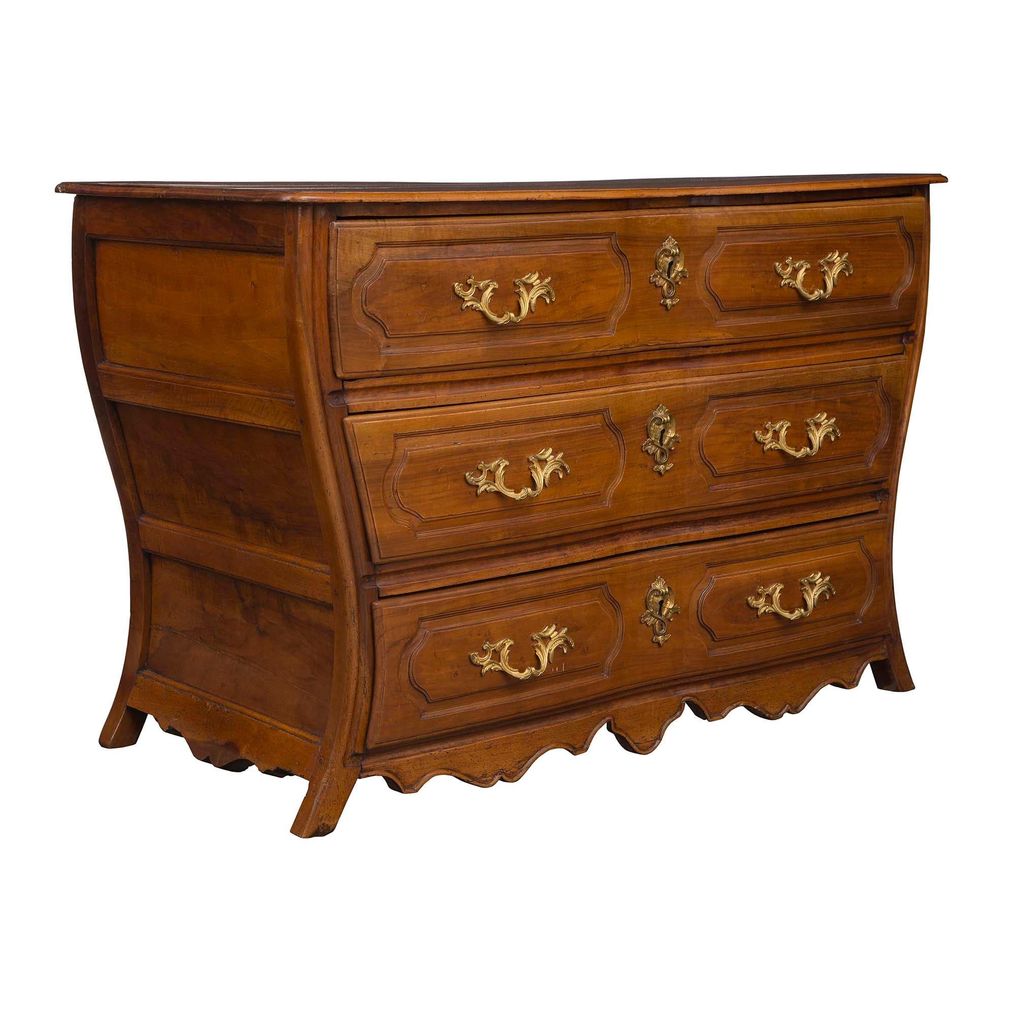 A very handsome French 18th century Louis XV period walnut and ormolu three-drawer commode. The chest is raised on slightly curved legs with a scrolled frieze and scrolled sides. The drawers have ormolu foliate handles on carved panels centered by