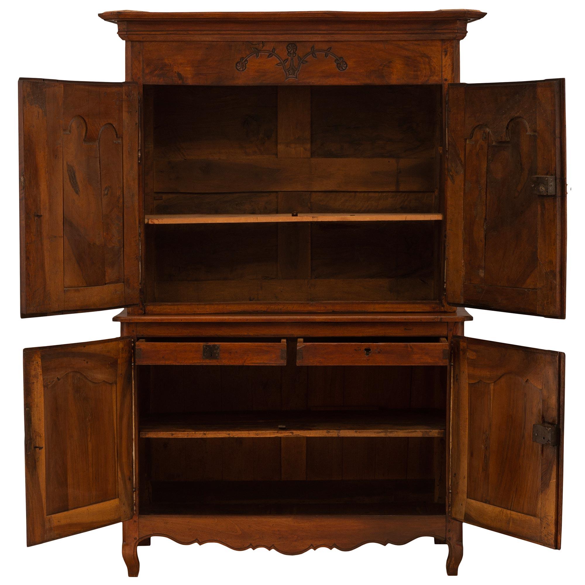 A fine French 18th century Louis XV period walnut 'Deux Corps', mounted with all of its original hardware. The bottom is raised by cabriole legs and has two doors above a scalloped apron. Inside lays the original shelf below two inside drawers.