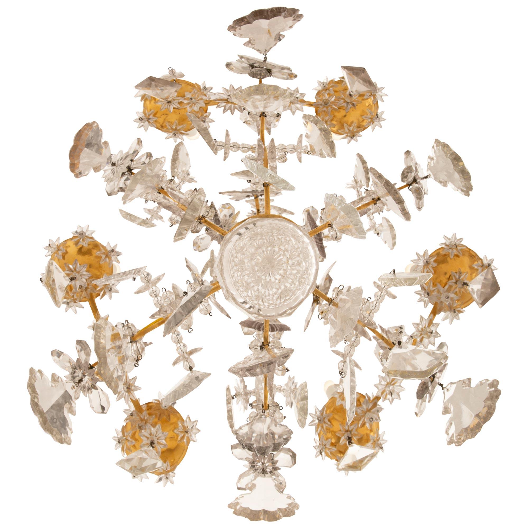 Magnifique lustre de grande qualité en bronze doré et cristal de Baccarat, datant du XVIIIe siècle, de style Louis XV. Ce lustre à six bras et six lumières est centré par une boule de cristal finement taillée avec une rosette et trois perles de
