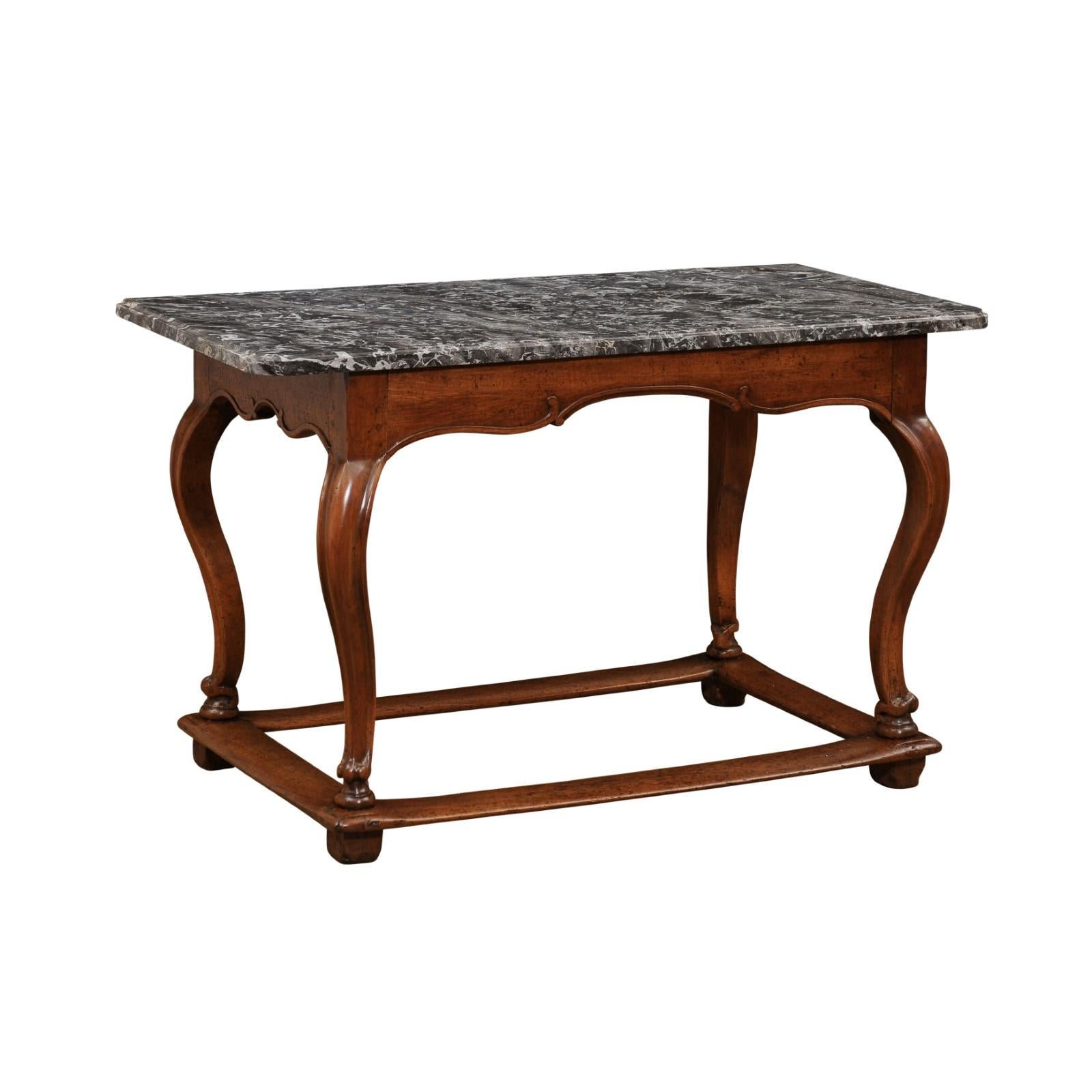 A French Louis XV period walnut center table from the 18th century, with grey marble top, cabriole legs and side stretchers. Created in France during the reign of King Louis XV nicknamed the Bien-Aimé (the Beloved), this center table features a