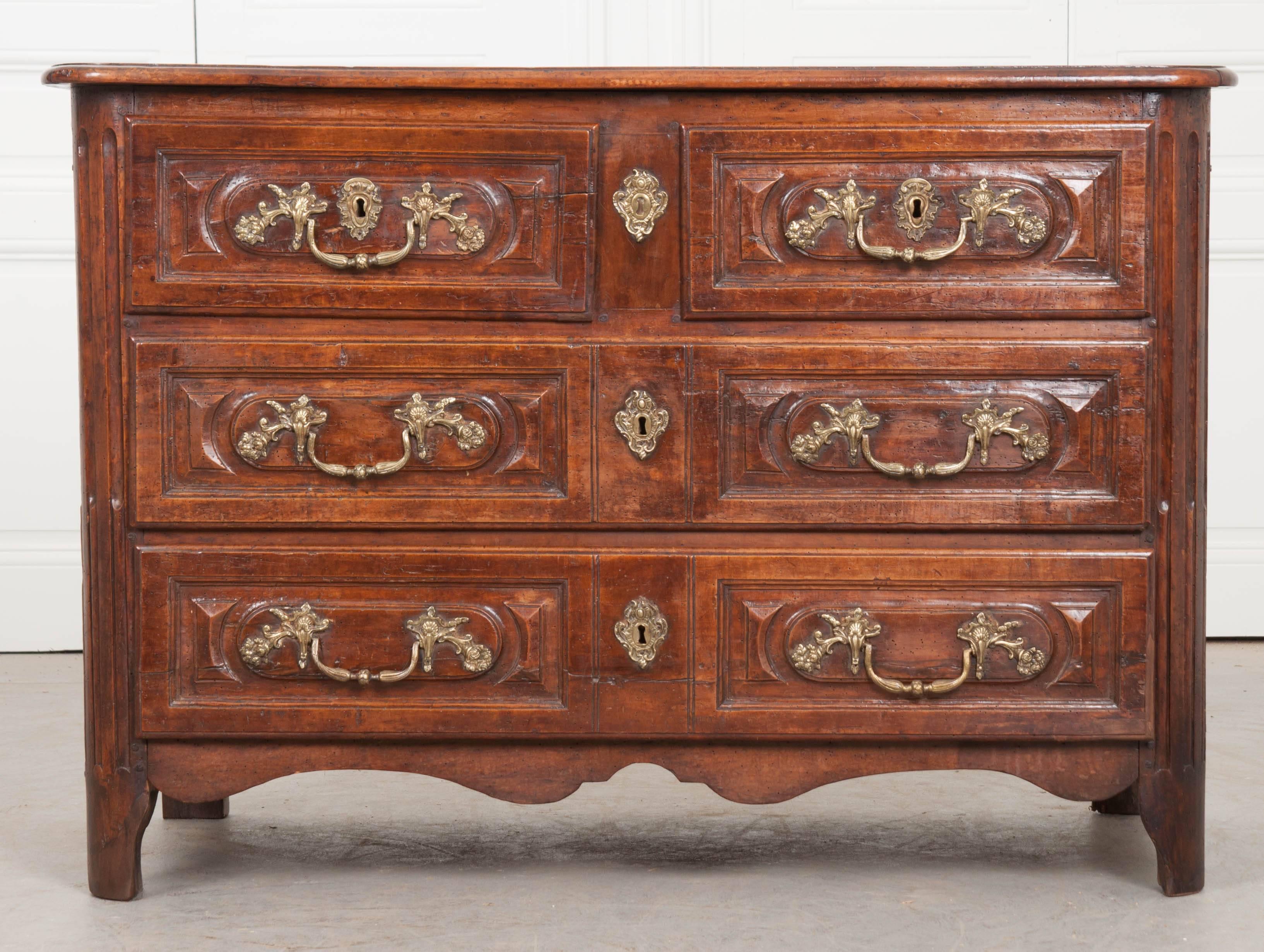 A stunning solid walnut Louis XV commode from 18th century, France. The beautiful walnut used to construct the commode has been hand-carved and fastened together using peg and hole joinery. Each of the four drawers has extraordinary brass hardware.