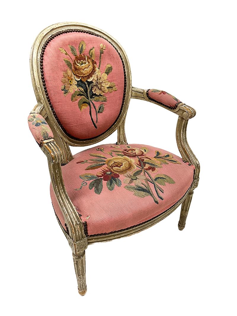 A French 18th Century Louis XVI children's chair.

A ca. 1775 French children's chair with an oval curved back with fluted legs and armrests. 
An antique embroidered seat, part of the armrests and back with flower motif. 
The chair shows traces