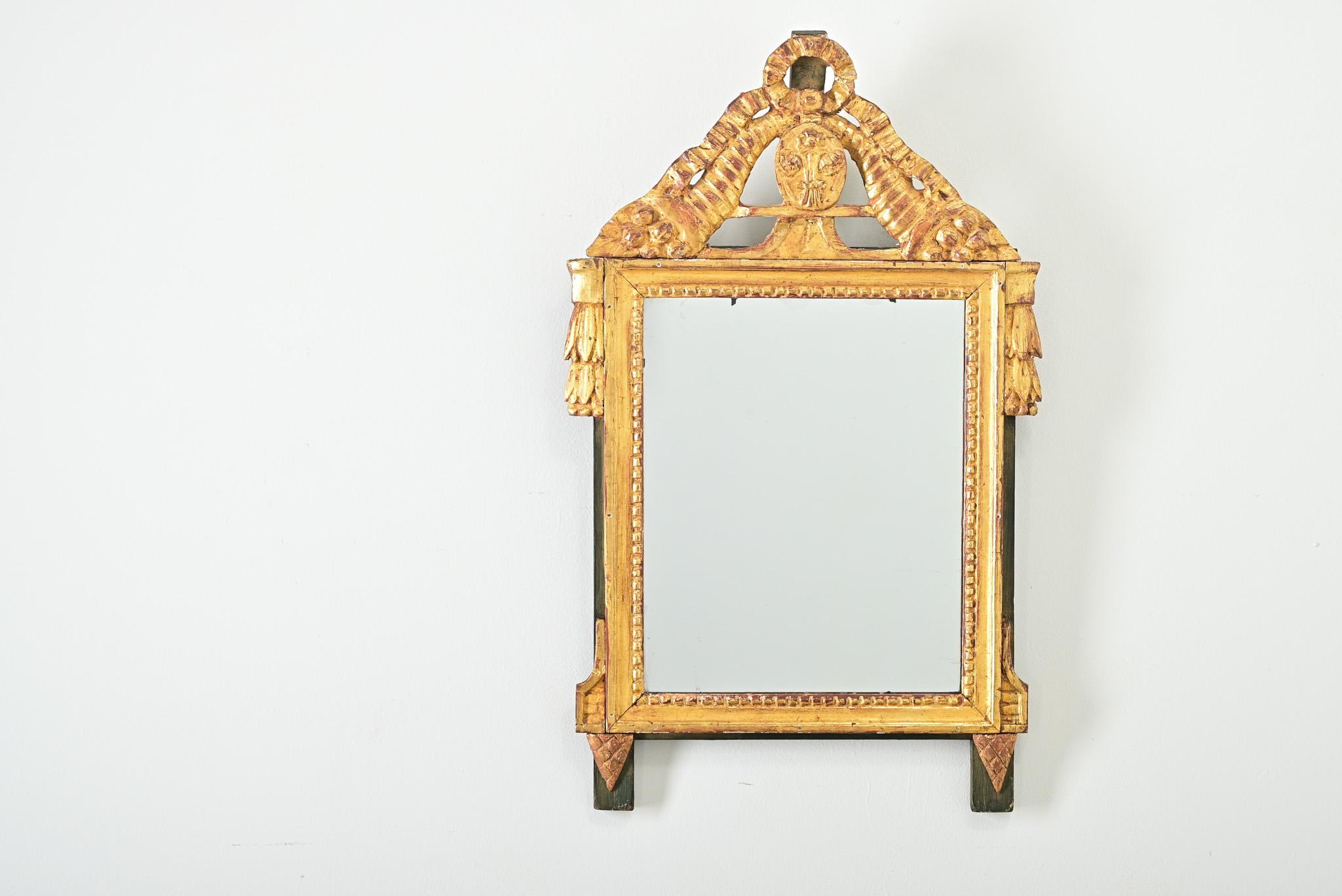 Miroir français en bois doré de style Louis XVI, vers 1790, avec d'incroyables motifs sculptés mis en valeur par le panneau arrière peint en vert profond. Partant du haut de la pièce, les rubans descendent en cascade jusqu'aux bords supérieurs du