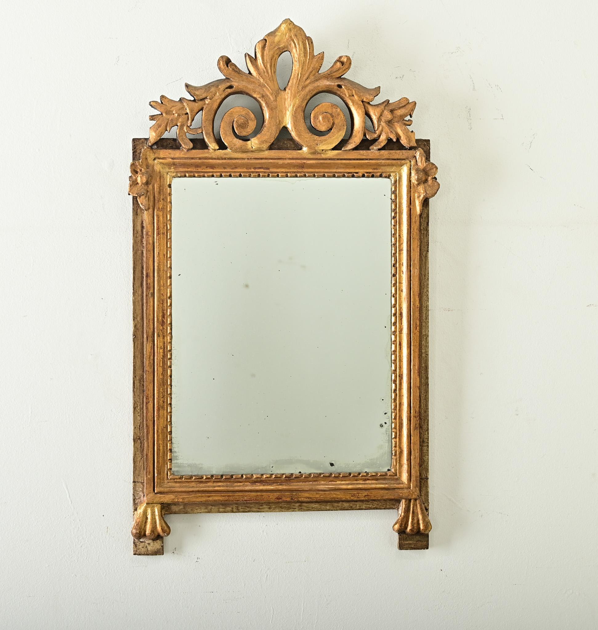 Unique miroir trumeau français de la période Louis XVI, datant du XVIIIe siècle, avec de fantastiques sculptures en bois doré appliquées au cadre en bois peint (patiné). Au-dessus de la plaque de miroir se trouve un emblème à enroulement qui se