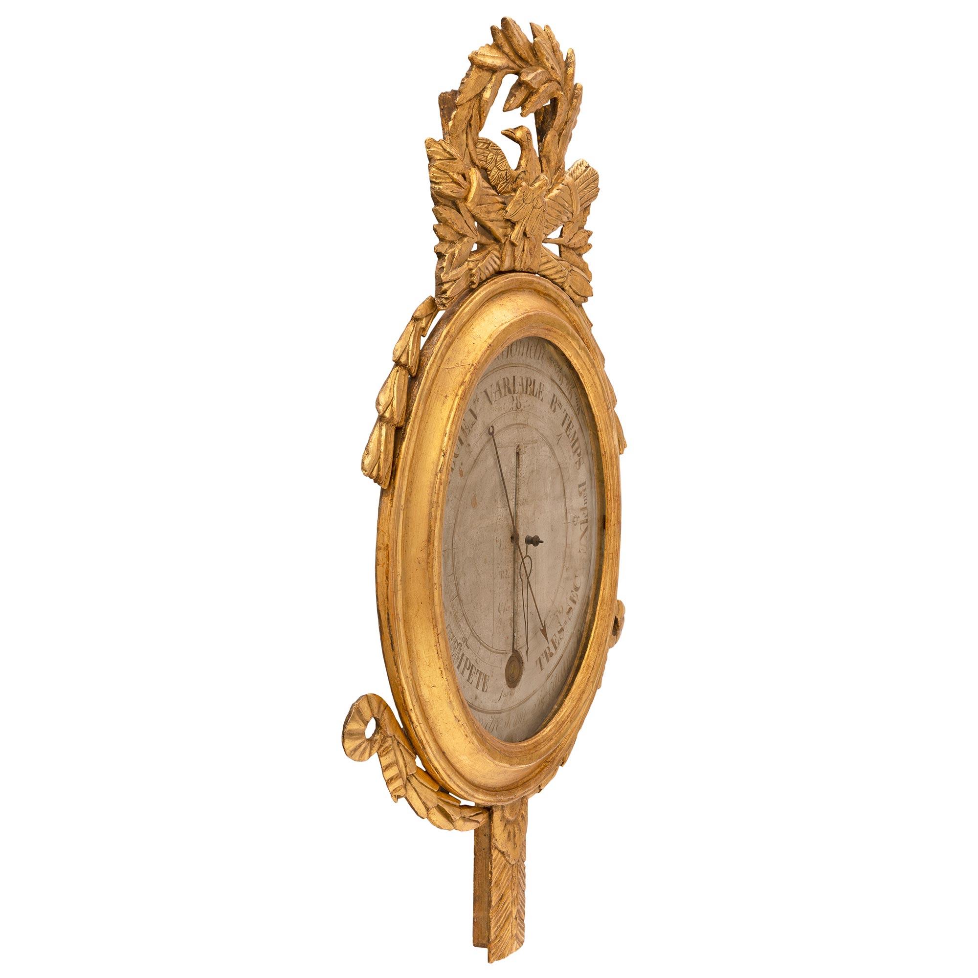An elegant and extremely decorative French 18th century Louis XVI period giltwood barometer thermometer. The most decorative barometer thermometer retains its original glass pane enclosing the display. The background is decorated with the original
