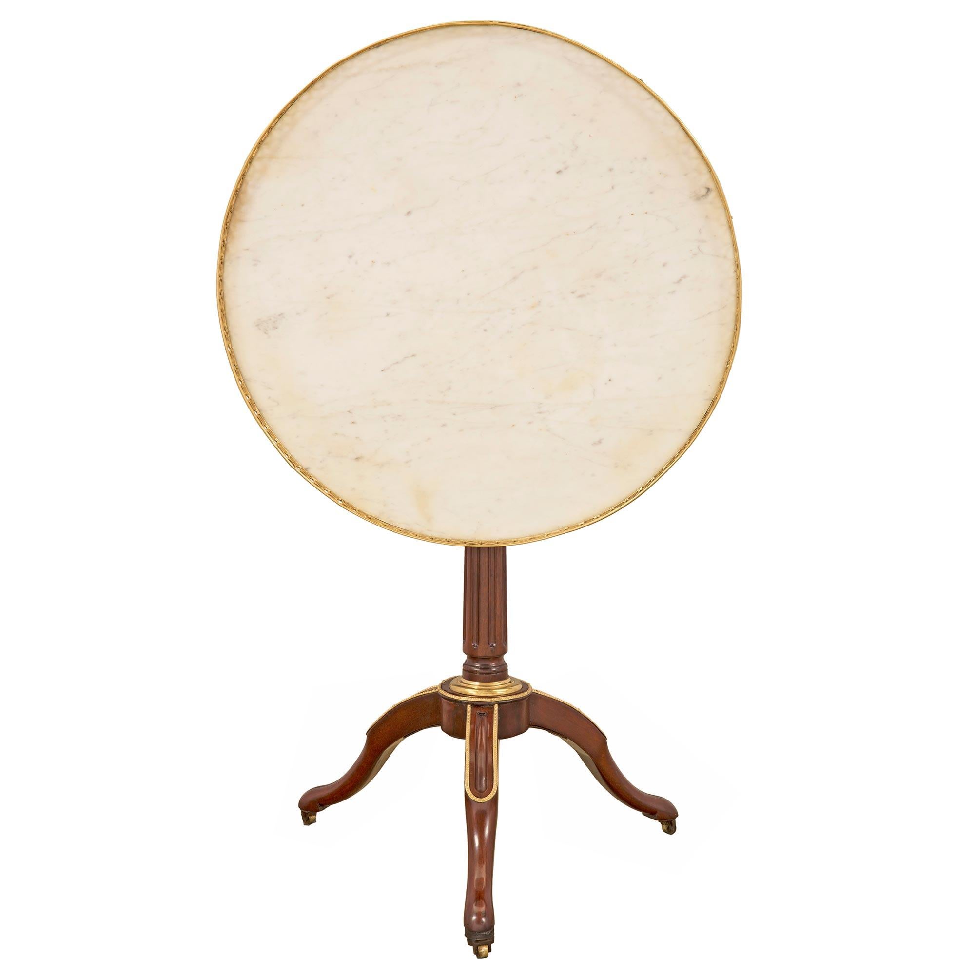 Table d'appoint de très grande qualité, d'époque Louis XVI, en acajou, bronze doré et marbre. La table est surélevée par trois pieds élégamment chantournés avec leurs roulettes d'origine et une belle bande perlée en bronze doré. Le support