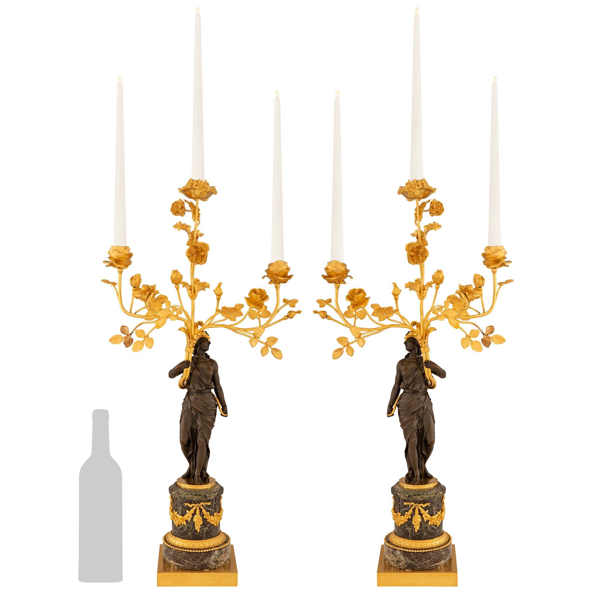 Una coppia elegante e di alta qualità di candelabri francesi del XVIII secolo in marmo Vert Patricia, Ormolu e bronzo patinato. Ogni meraviglioso candelabro a tre bracci è sostenuto da un basamento quadrato in Ormolu con un piedistallo circolare. Il
