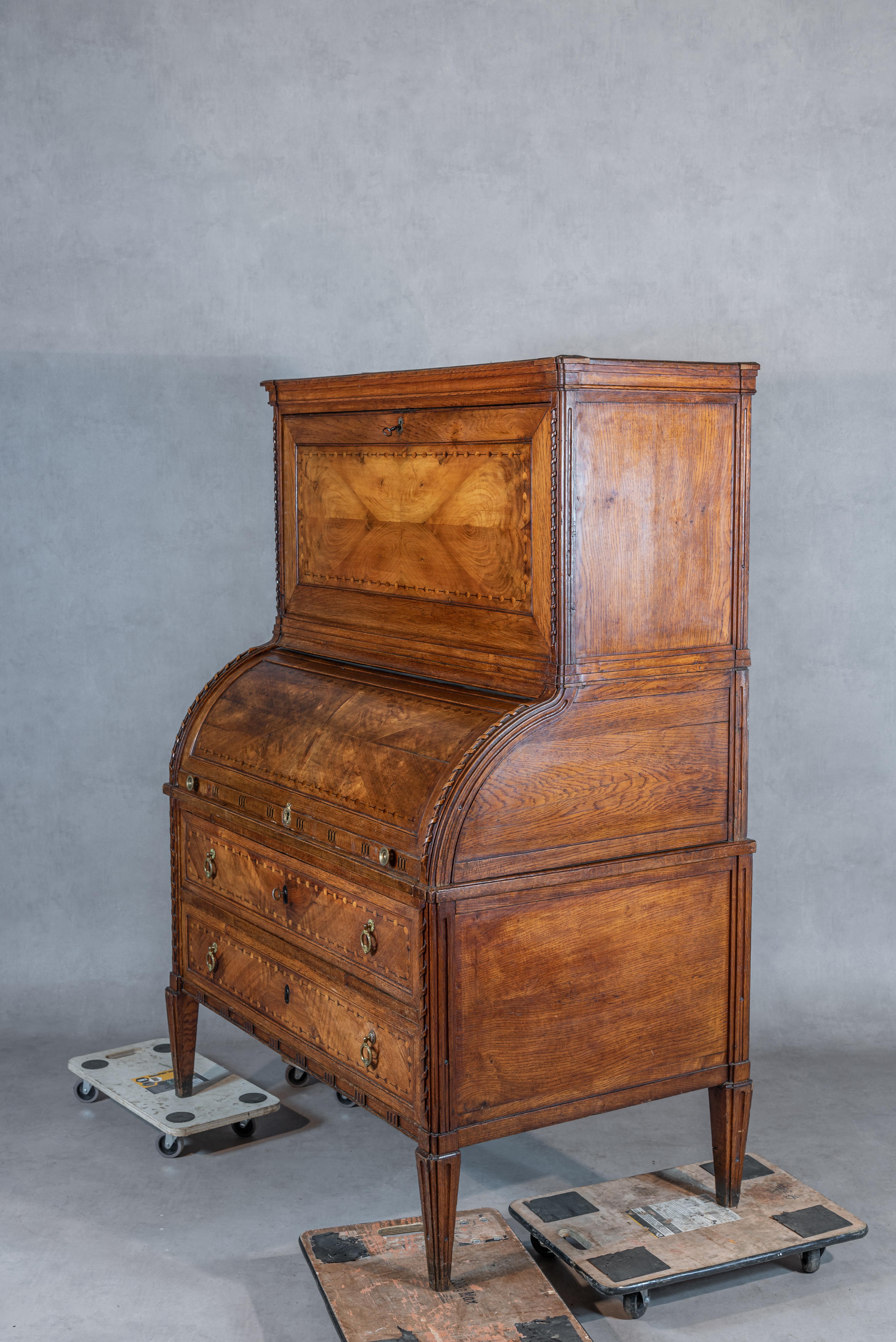 An exceptional French 18th century Louis XVI Period Marquetry Desk. This desk is known as a “bureau a cylindre”, referring to its curved pivoted opening in the middle. The woodwork on this piece is spectacular: made of solid oak and featuring