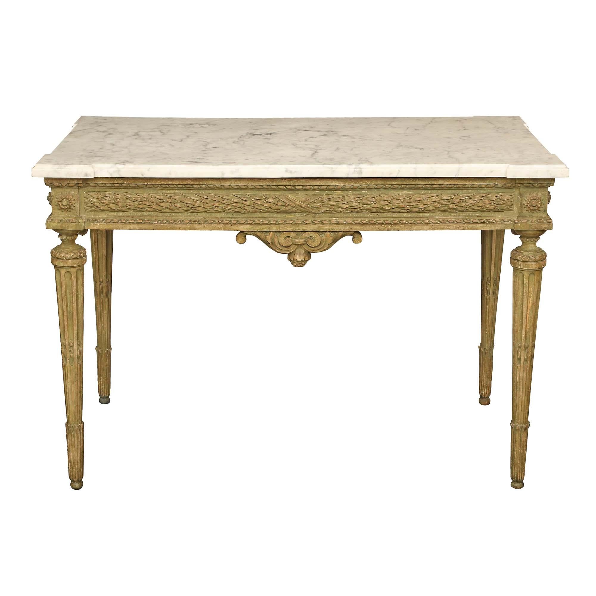 Un delizioso tavolo da centro francese del XVIII secolo di epoca Luigi XVI patinato con il piano in marmo originale. Il tavolo è sollevato da gambe circolari affusolate e scanalate con accenti foliati. Il fregio dritto è centrato da un terminale a