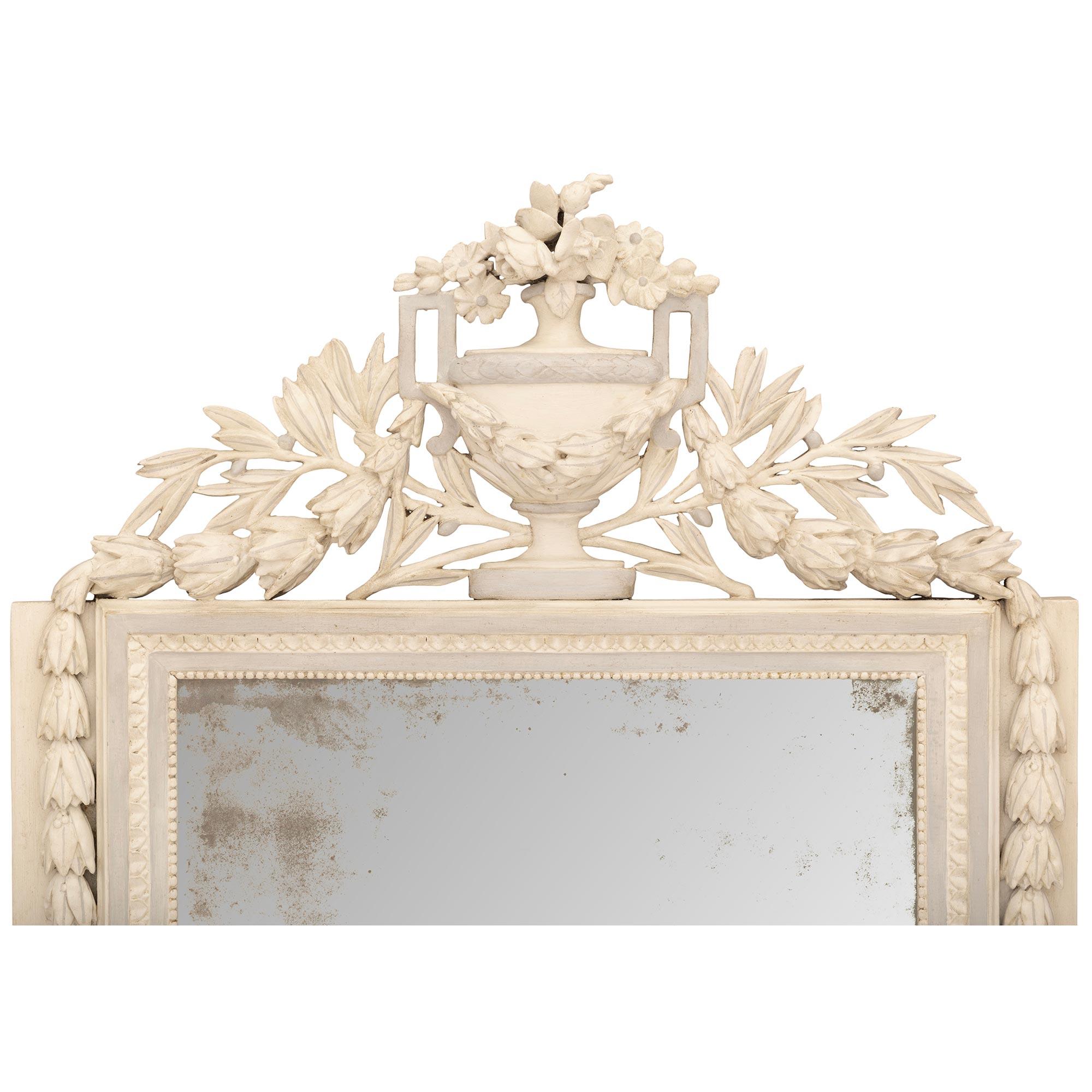 Ein einzigartiger und äußerst dekorativer französischer Spiegel aus patiniertem Holz aus dem 18. Jahrhundert im Louis-XVI-Stil. Die originale Spiegelplatte befindet sich in einem patinierten weißen Rahmen und wird von den Ecken des Sockels aus von