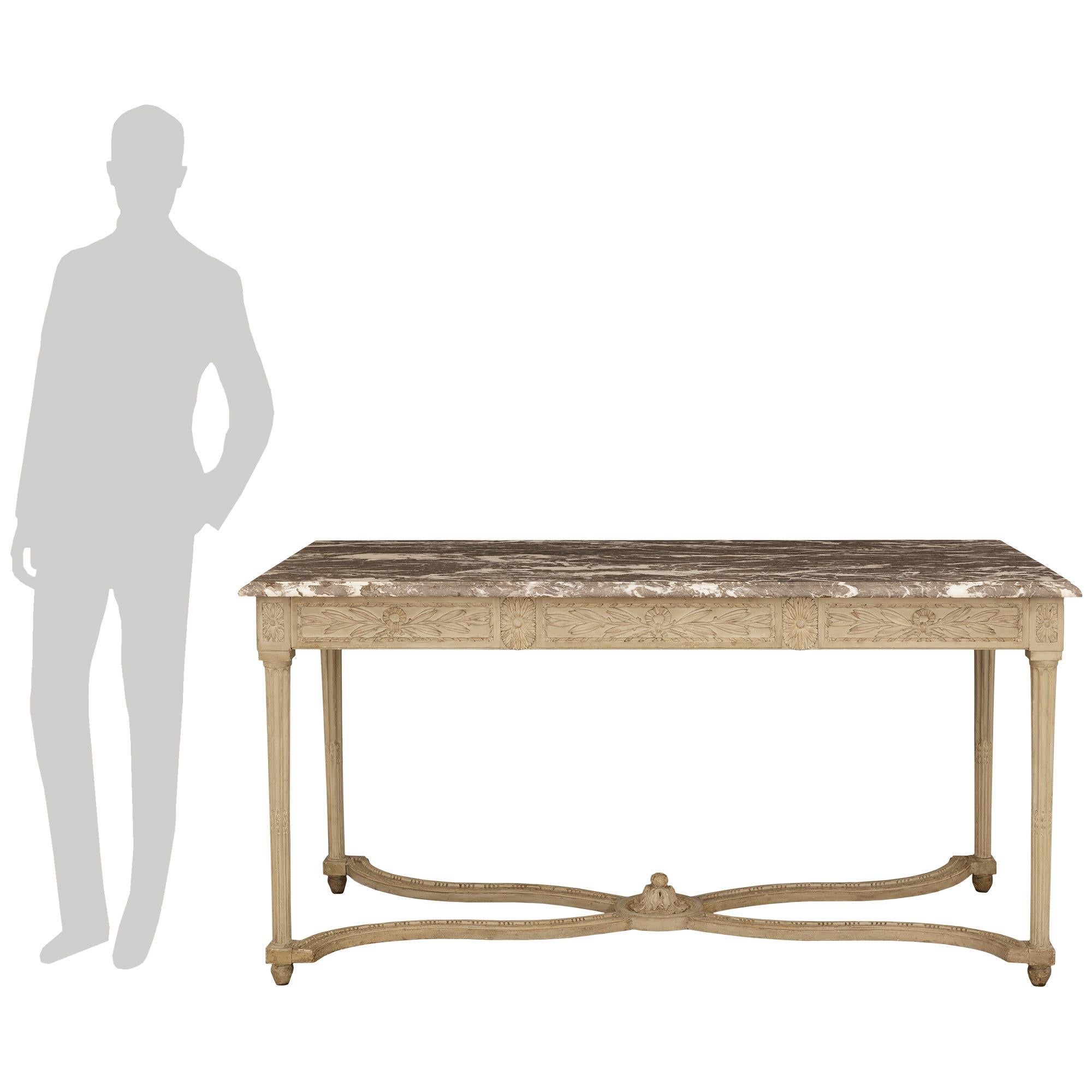Un'elegante e decoratissima console francese della metà del XVIII secolo in legno patinato e marmo Gris St. Anne. Questa splendida consolle indipendente di colore grigio patinato è sollevata da quattro gambe circolari scanalate che poggiano su