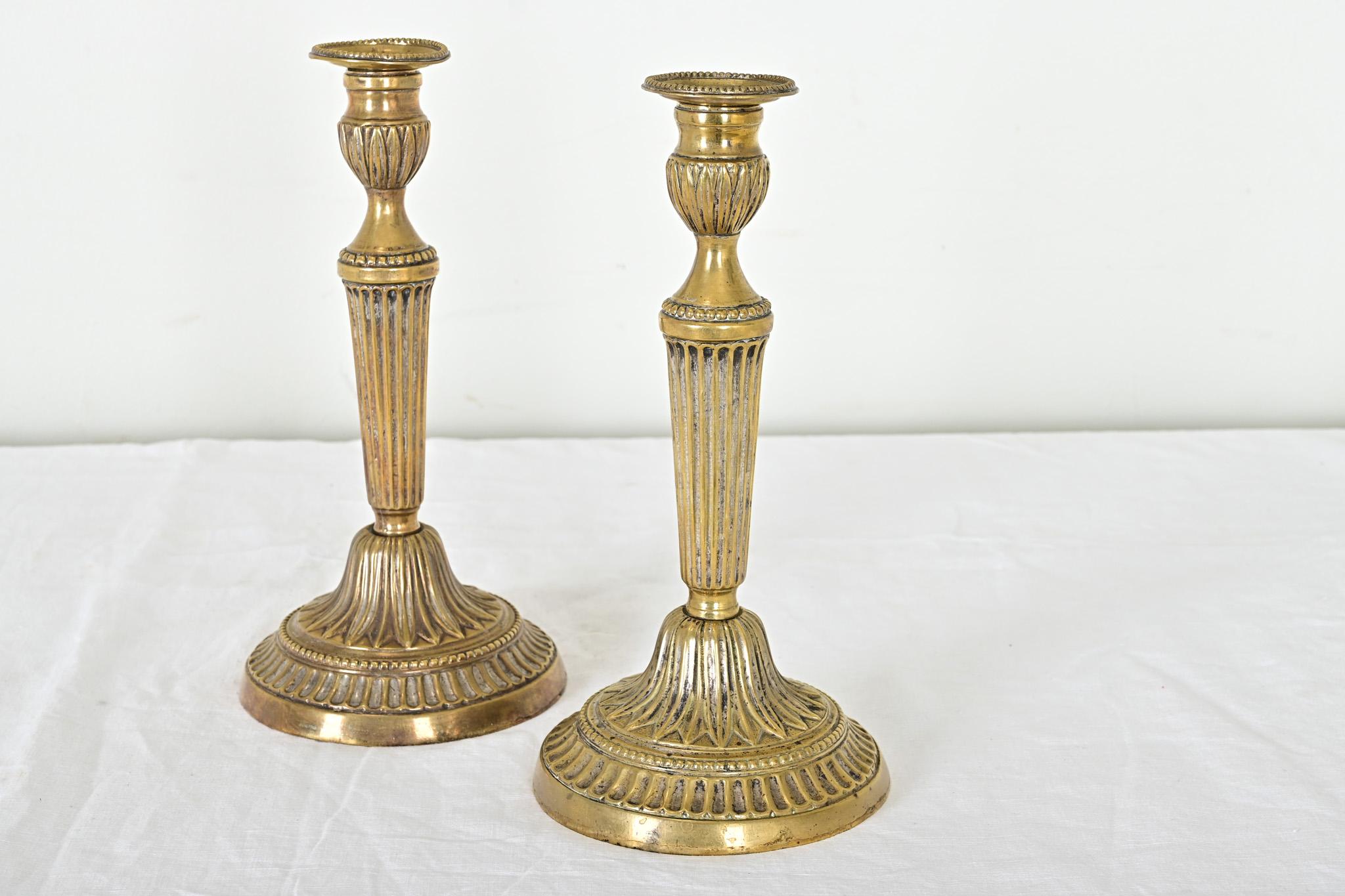 Candeleros franceses de plata y latón del siglo XVIII de excepcional calidad, época Luis XVI. Se aprecian sutiles influencias neoclásicas en las texturas estriadas y los bordes rebordeados de la decoración de la superficie, con motivos foliados como