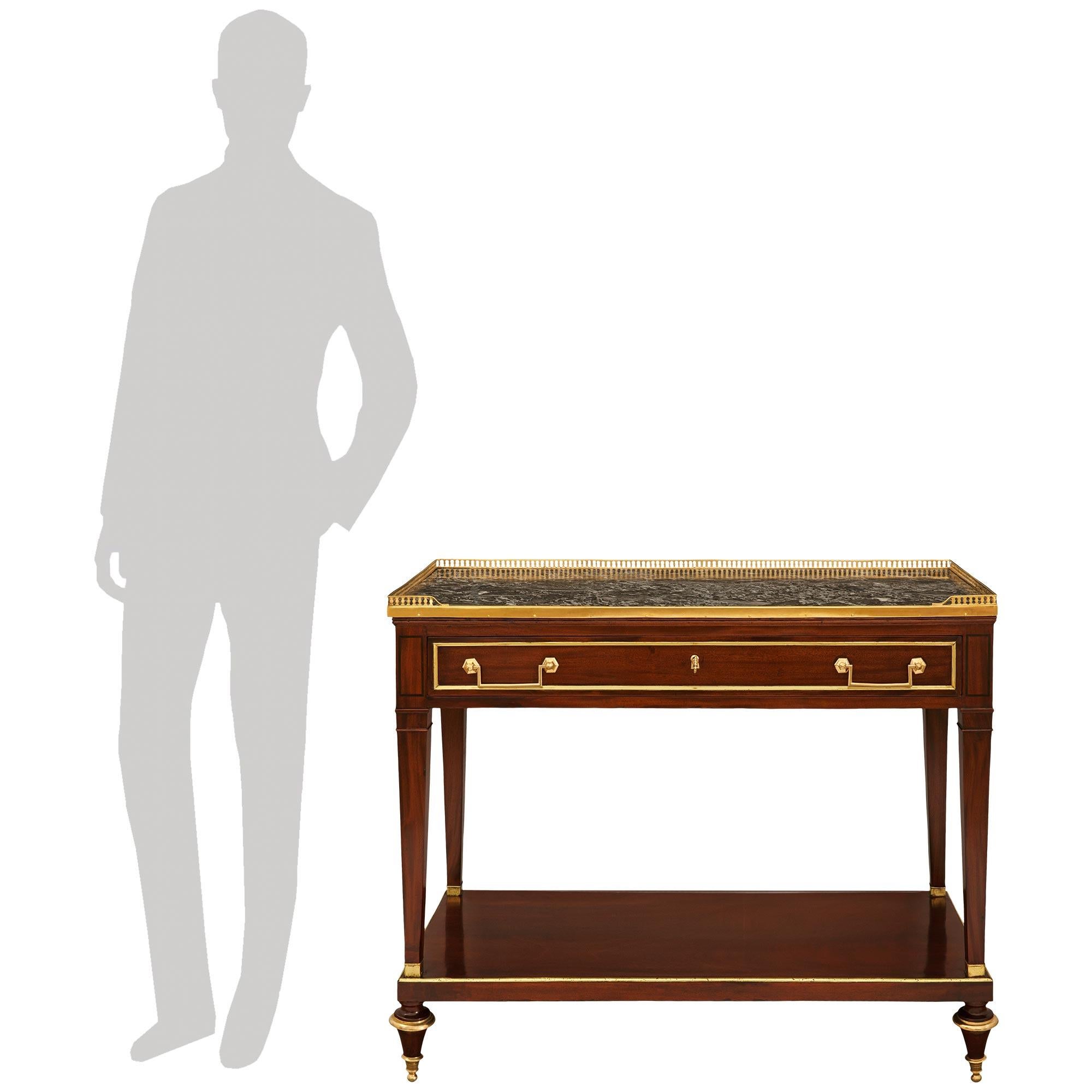An elegant and high quality French 18th century Directoire Period Mahogany, Ormolu and Gris St. Anne marble console, circa 1795. This stunning console is raised on toupie shaped feet with mottled Ormolu top and bottom bands below a rectangular