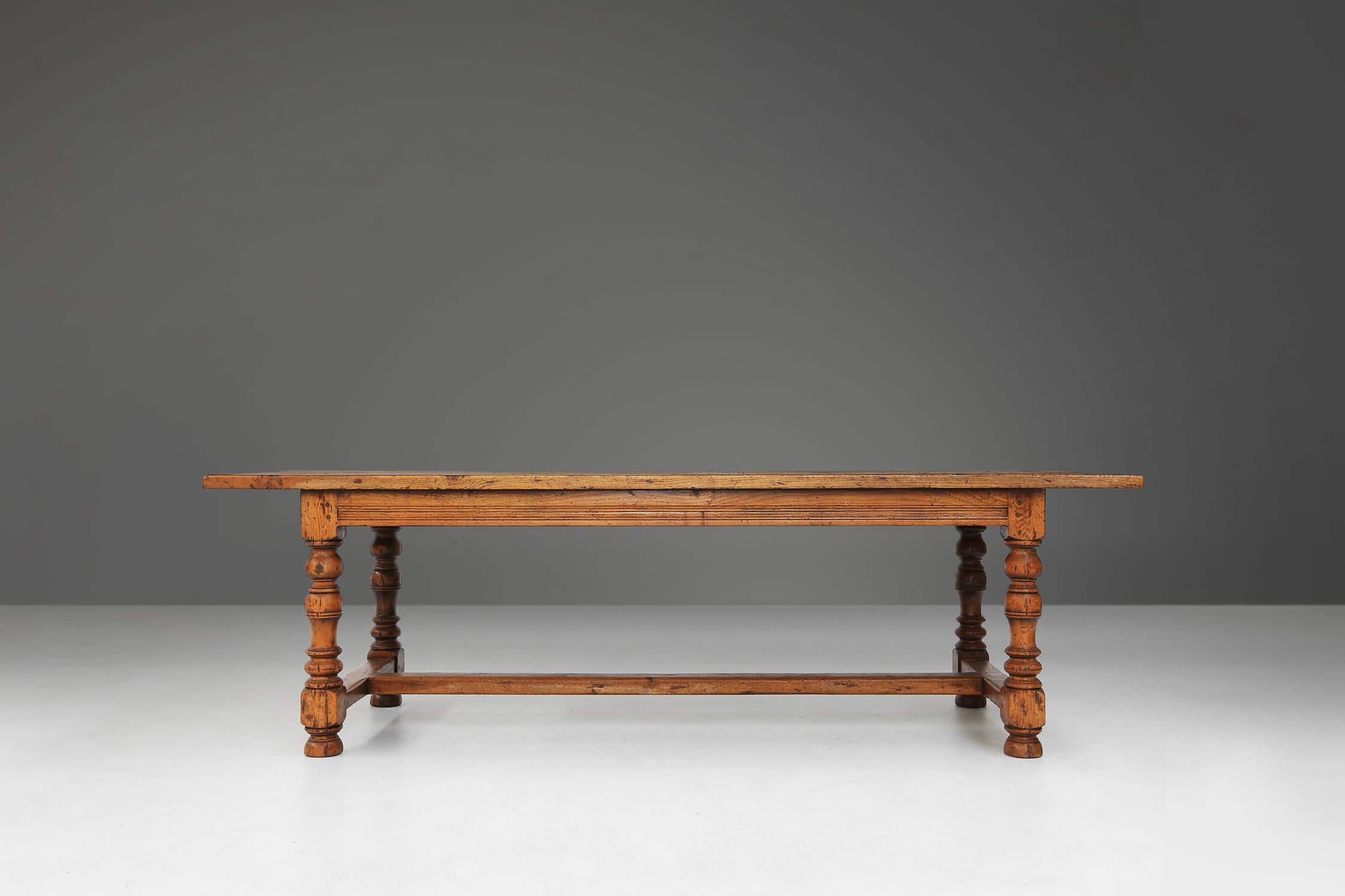 Made in the 18th century in full oak, this antique French table is a unique and quality piece of furniture. It has turned legs and a crossbar, which are connected with a tapered joint. This is a traditional and sturdy way of attaching wooden parts