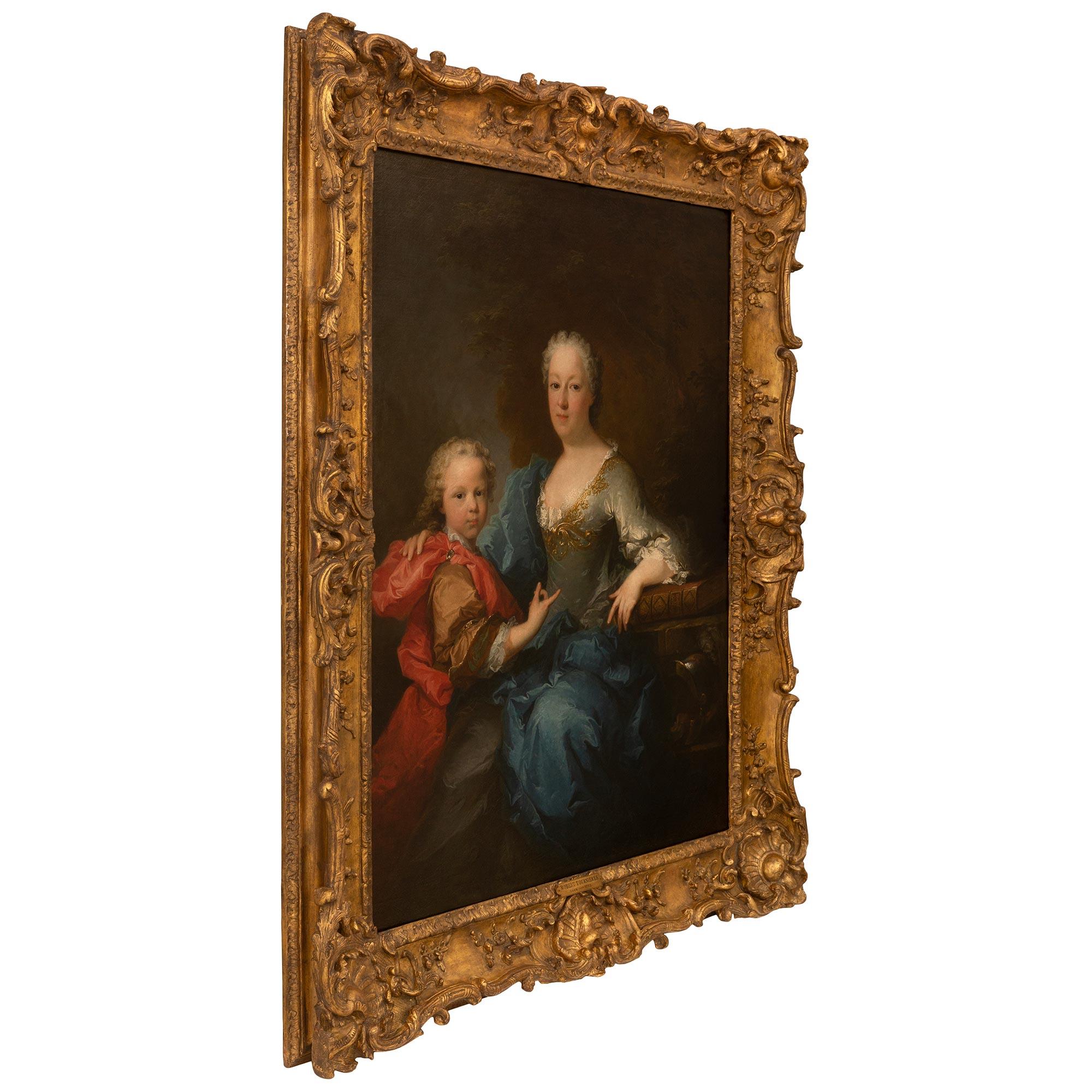 A wonderful French 18th century Oil on Canvas and Giltwood painting of a mother and son by Robert Le Vrac de Tournières. The painting is framed within a richly carved giltwood frame with stunning seashell reserves at the center and at each corner.