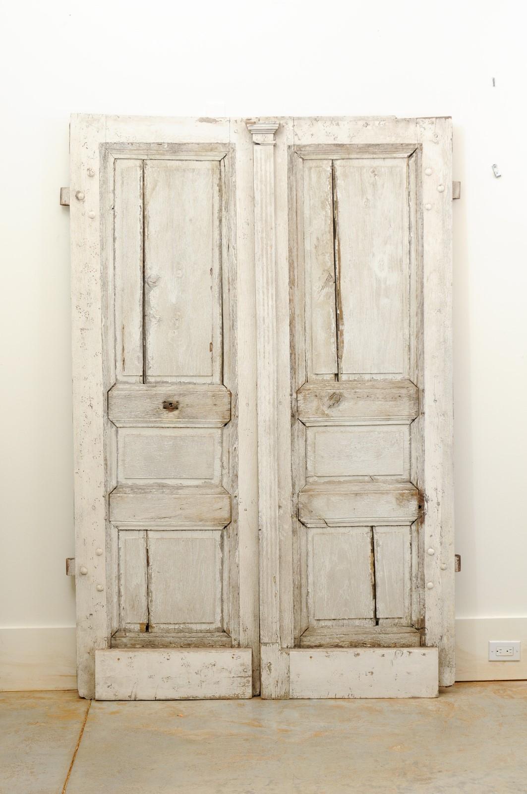 French painted oak double doors from the 18th century, with Doric pilaster, recessed panels and nicely weathered appearance. Created in France during the 18th century, these double doors charm us with their clean lines and nicely aged patina.