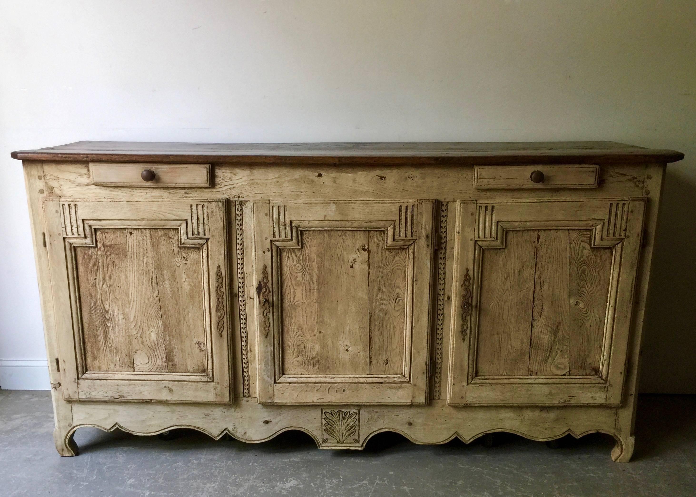 Handsome 18th century enfilade transition in Louis XV and Louis XVI period with three raised panel doors and drawers, carefully carved apron in superb bleached patina all topped with beautifully worn darker oak top
France, circa 1750.
 