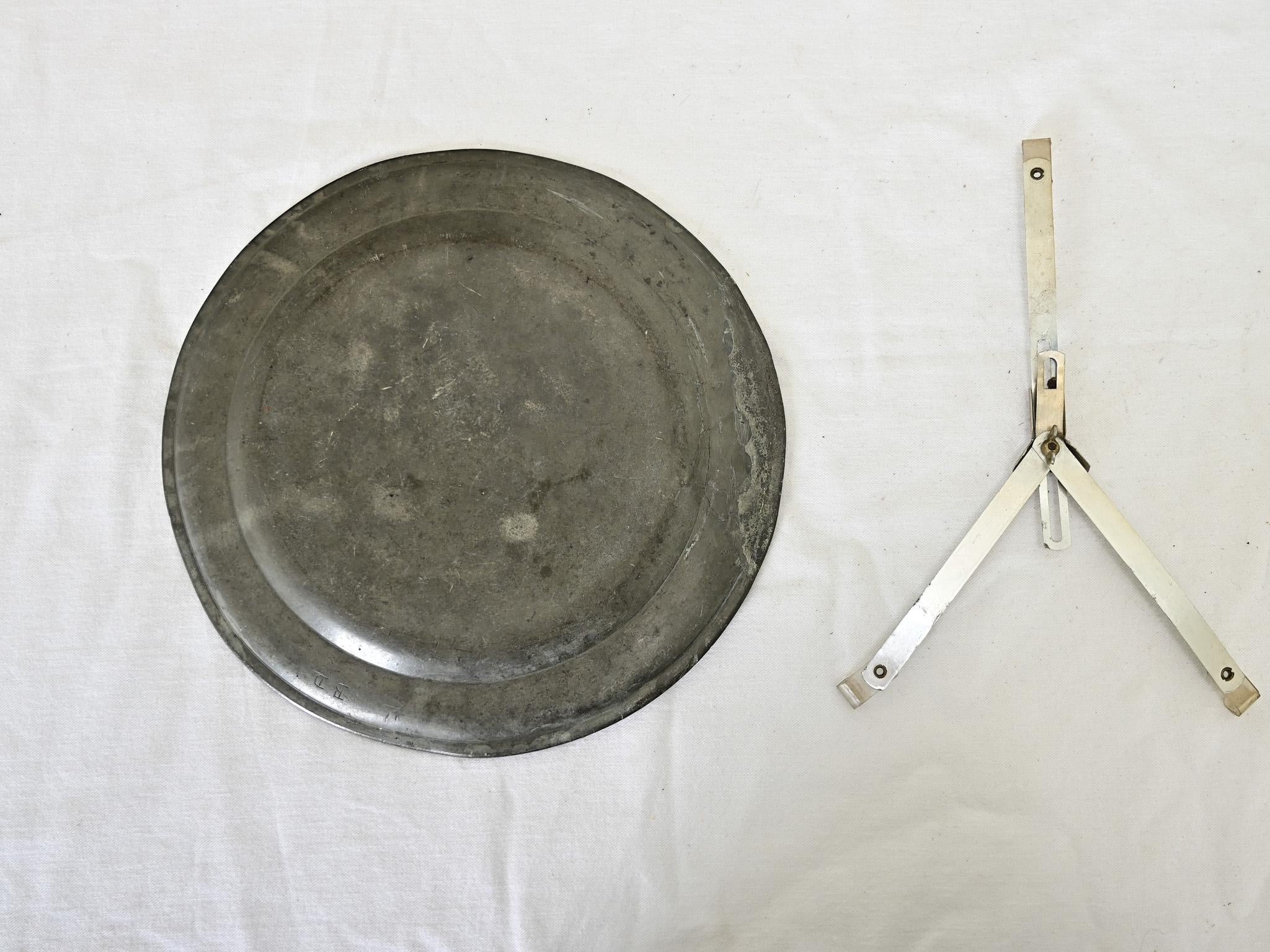 An exceptional example of the European pewter tradition, this ceremonial charger plate from France dates to the year 1735 and depicts an exchange between the Saints Peter and Paul that has been meticulously etched into the metal for a commemorative