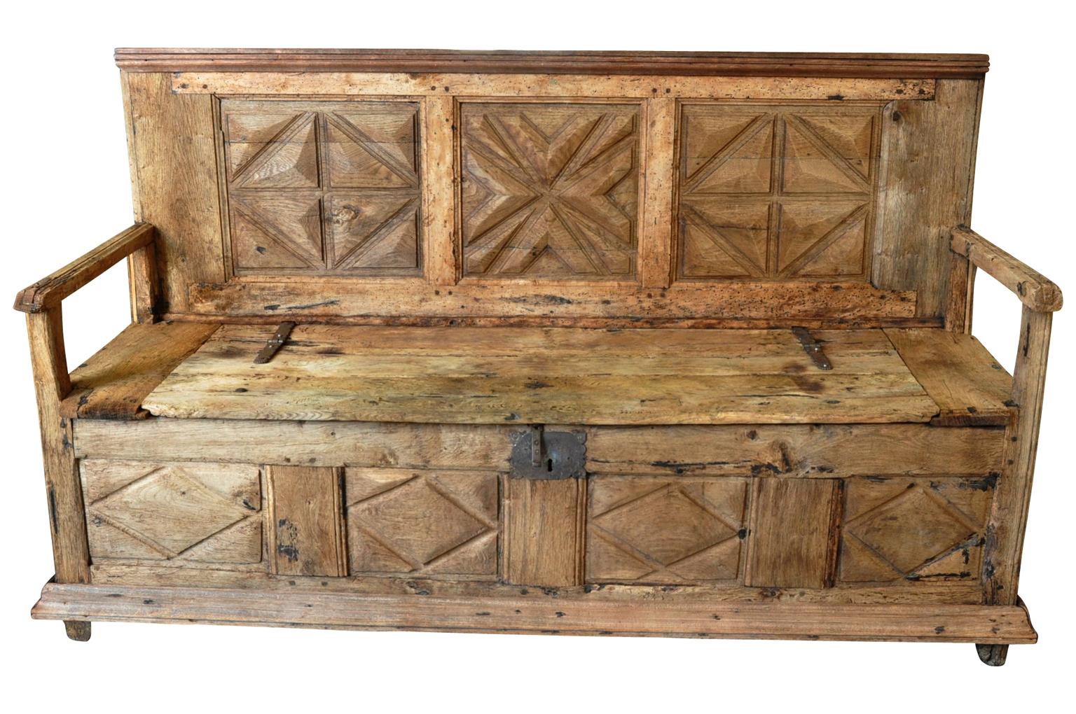 A very handsome and Primitive Louis XIII style bench. Wonderfully constructed from washed oak with a beautiful carved paneled back with lifting seat. Great storage.