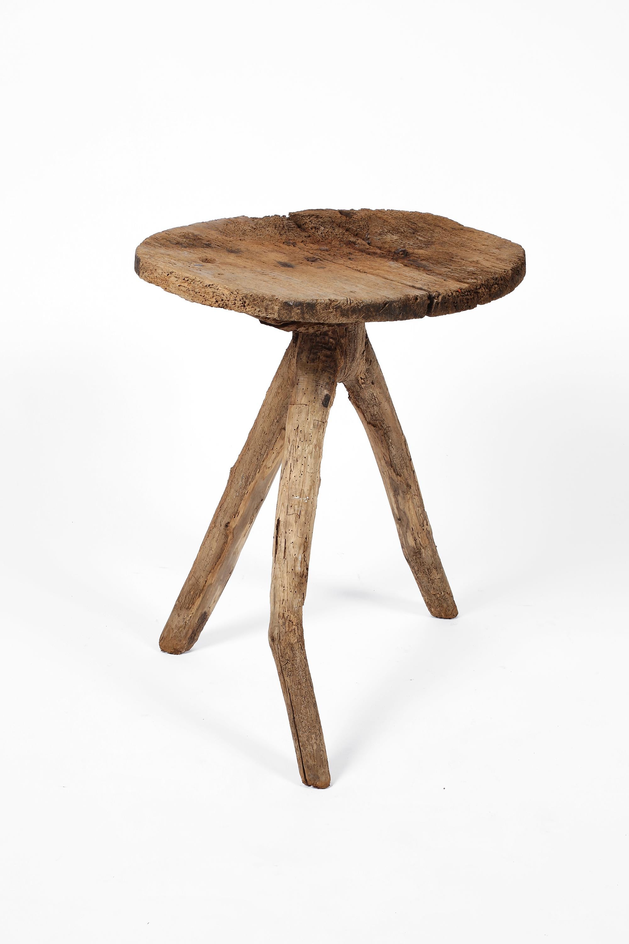 A highly original and primitive mountain table constructed from mixed timbers. The heavily patinated and time-worn with visible iron nails, the circular top honestly fixed to an organic tripod base. French, c. 1750.