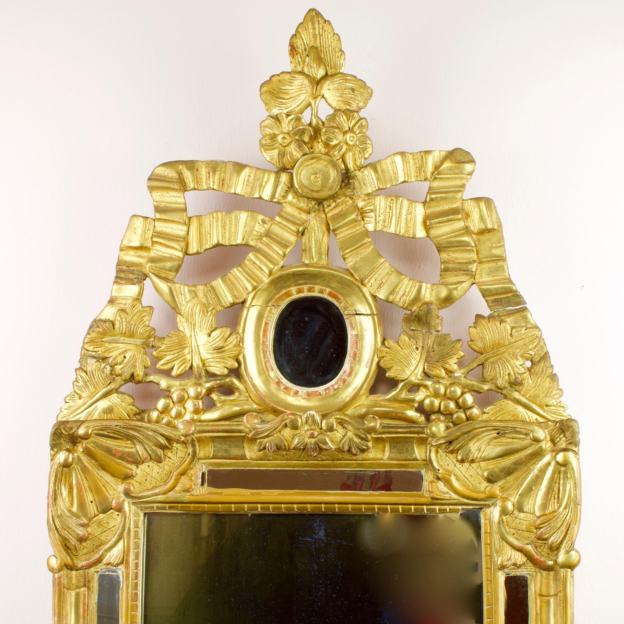 Miroir mural en bois doré du XVIIIe siècle, de style Transition Provençale/Louis XVI, à décor de rubans

Un cadre en bois doré avec une plaque de miroir ancien, dans une bordure de miroir, les coins du début avec des feuilles d'acanthe, la crête