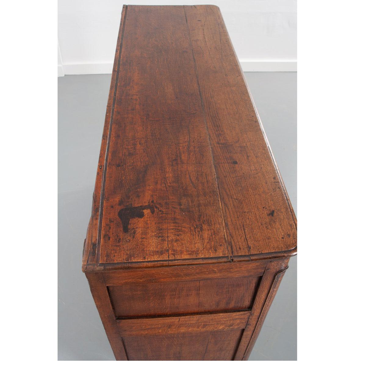 A fantastic Provincial buffet, made of quarter sawn oak, from 1780s, France. This beautiful solid oak case antique features exceptional decorative carvings, all done by hand, that are found on antiques dating to the countryside in this time period.