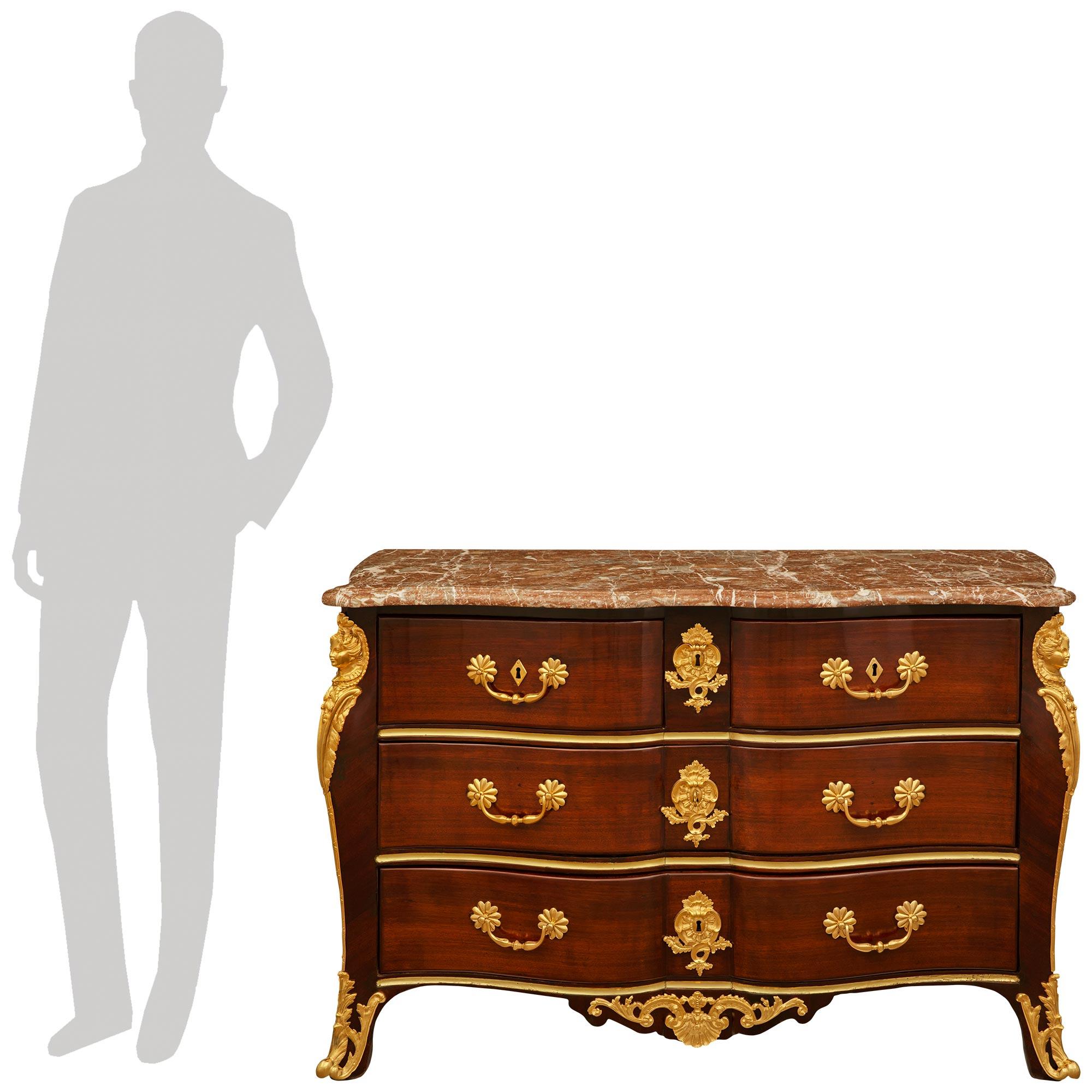 A high quality and most attractive French early 18th century Regence Period Mahogany, Ormolu and Rouge Royale marble commode, circa 1720. This stunning chest is raised on cabriole legs with fanciful pierced acanthus leaf decorated Ormolu sabots. The