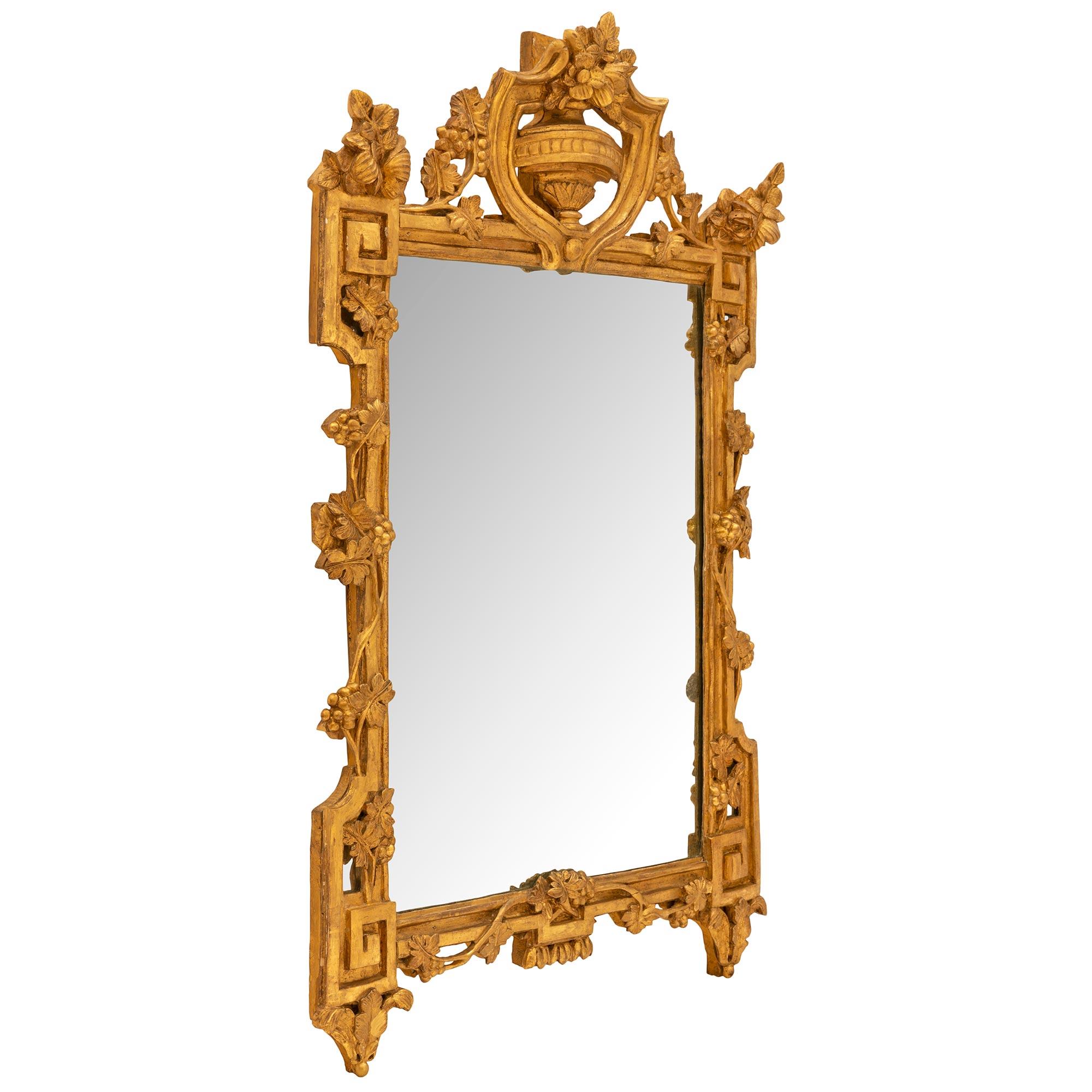 Ein schöner französischer Spiegel aus der Régence-Periode des 18. Jahrhunderts aus provenzalischem Goldholz. Der Spiegel behält seine originale Spiegelplatte, die von einer gesprenkelten Goldholzeinfassung umrahmt ist. Die Umrandung zeigt ein