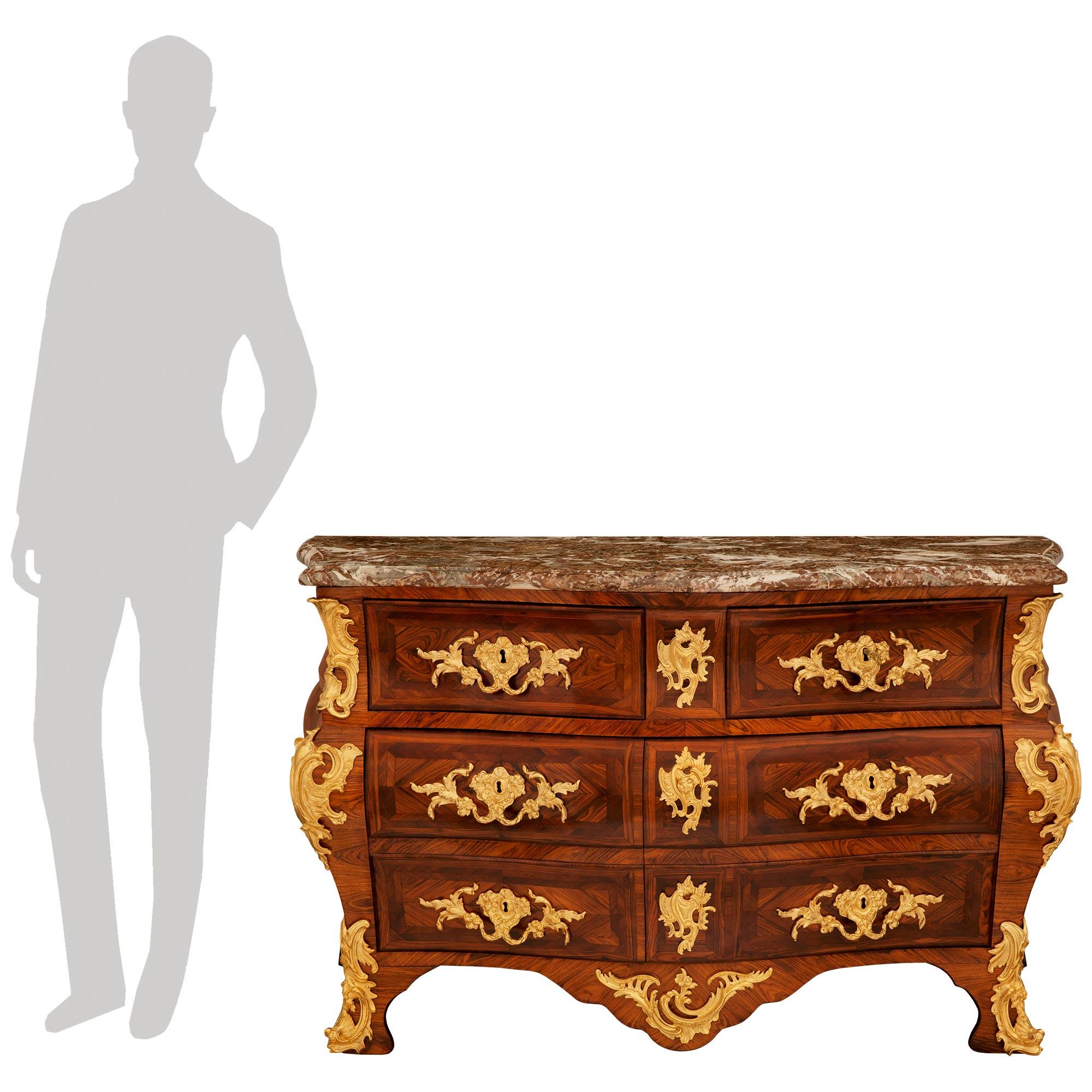 Eccezionale commode francese del XVIII secolo del periodo Régence in noce, ormolu e marmo Sarrancolin, firmata Bernard I Van Risenburgh. Questa splendida commode a forma di Bombee si erge su gambe elegantemente ricurve e ornate da decorazioni in