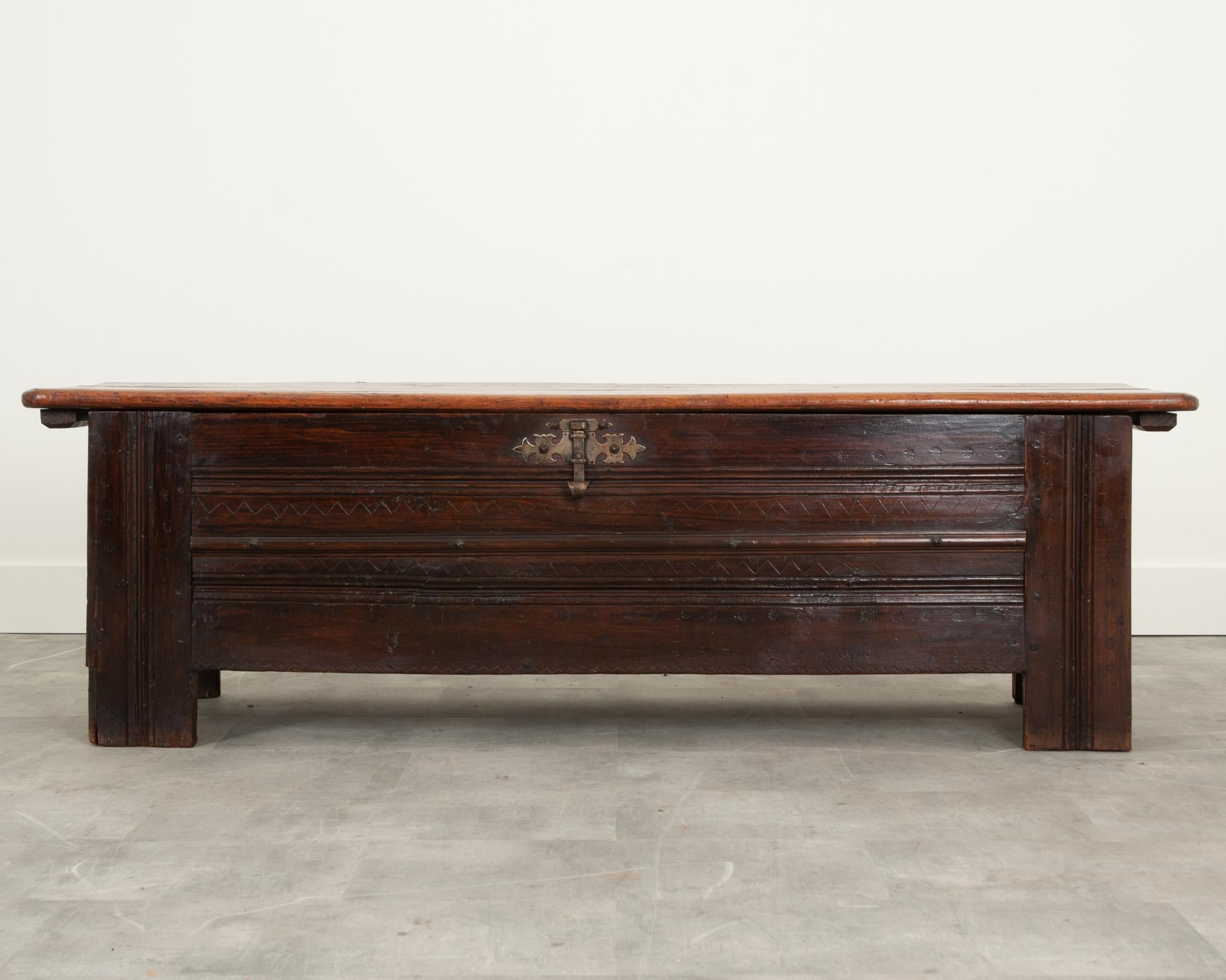 French solid oak coffer in wonderful antique condition. Made in the 1700’s, this coffer has hand-crafted details throughout that show the craftsmanship of many centuries past. The facade showcases decorative forged metal nails, a large metal latch