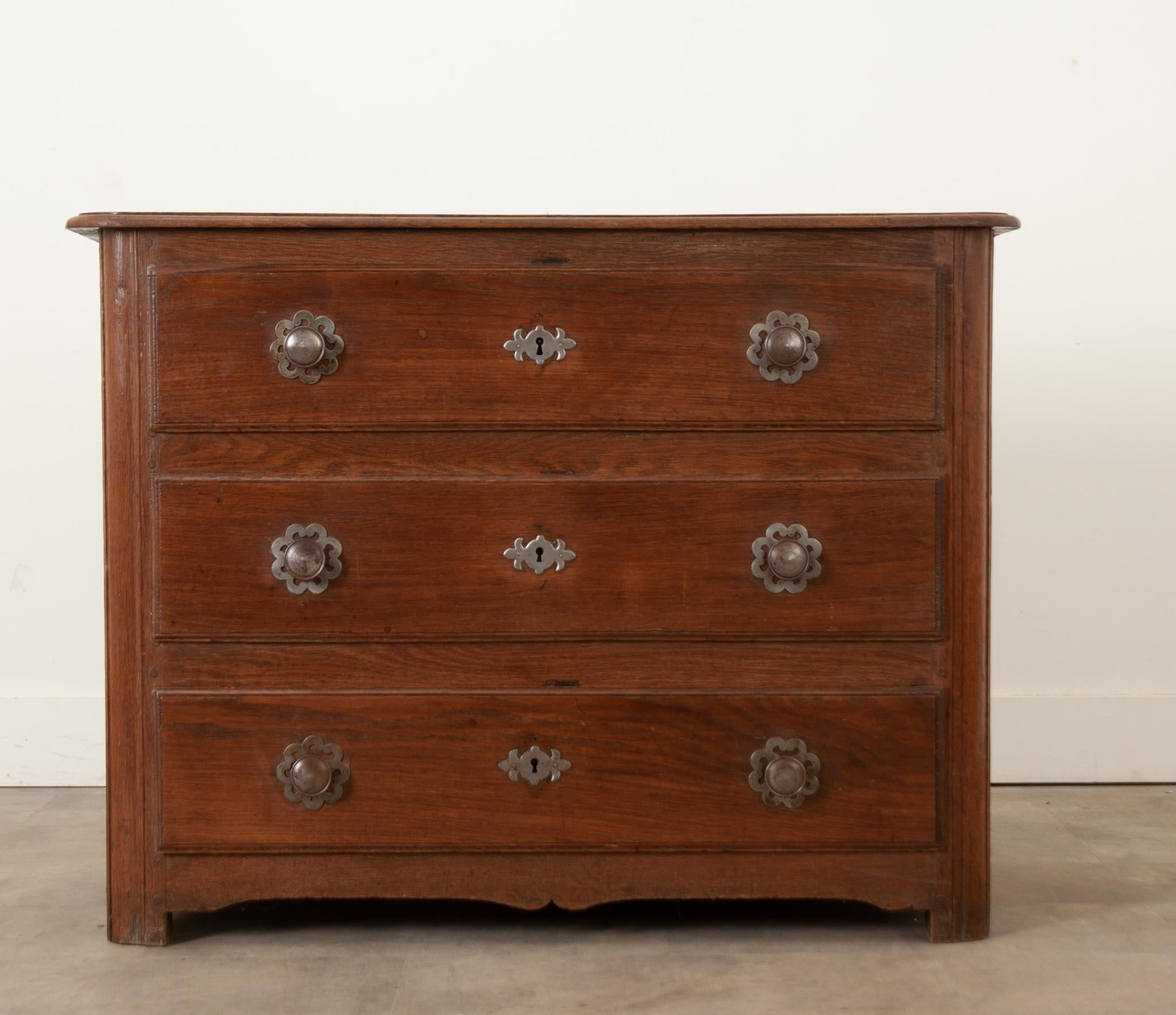 A handsome French commode made in the 1780’s of solid oak. The drawers have intricately hand cut steel escutcheon plates and knobs. The drawers have been cleaned and slide open with ease. This commode has been tightened and polished with a French