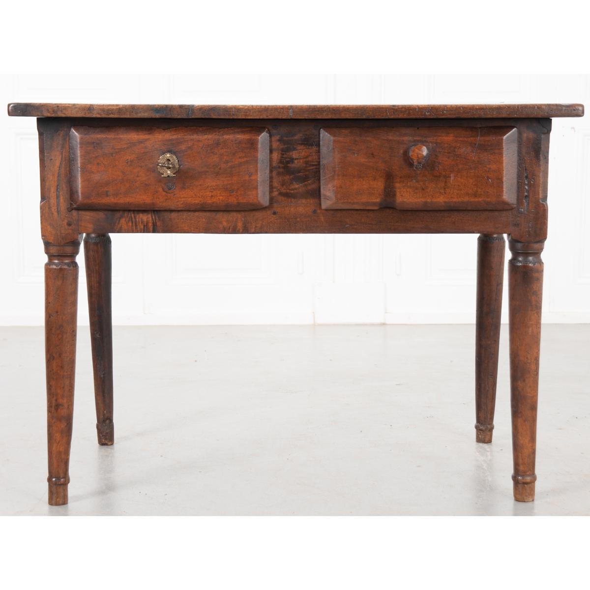 This is a French 18th century solid oak table. It is circa 1780. The top is well used and has a wonderful patina. It has two large drawers, one with a wood pull and one with a lock, key, and escutcheon. The escutcheon plate and lock are not the