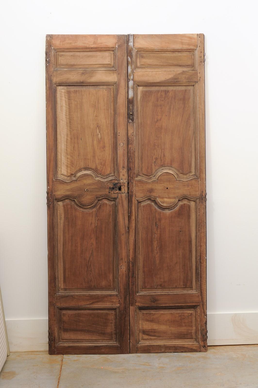 A pair of French walnut doors from the 18th century, with molded panels. Crafted in France from walnut during the 18th century, these double doors will make for an excellent architectural addition to any home decor. Their tall linear silhouettes are