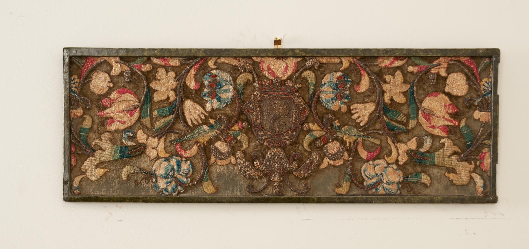 An elongated and framed French antique tapestry fragment from the 18th century depicting Baroque flowers and birds made from a number of fibers including silk and gold threads. Hand-woven by a workshop in the 1700s, this amazing tapestry fragment