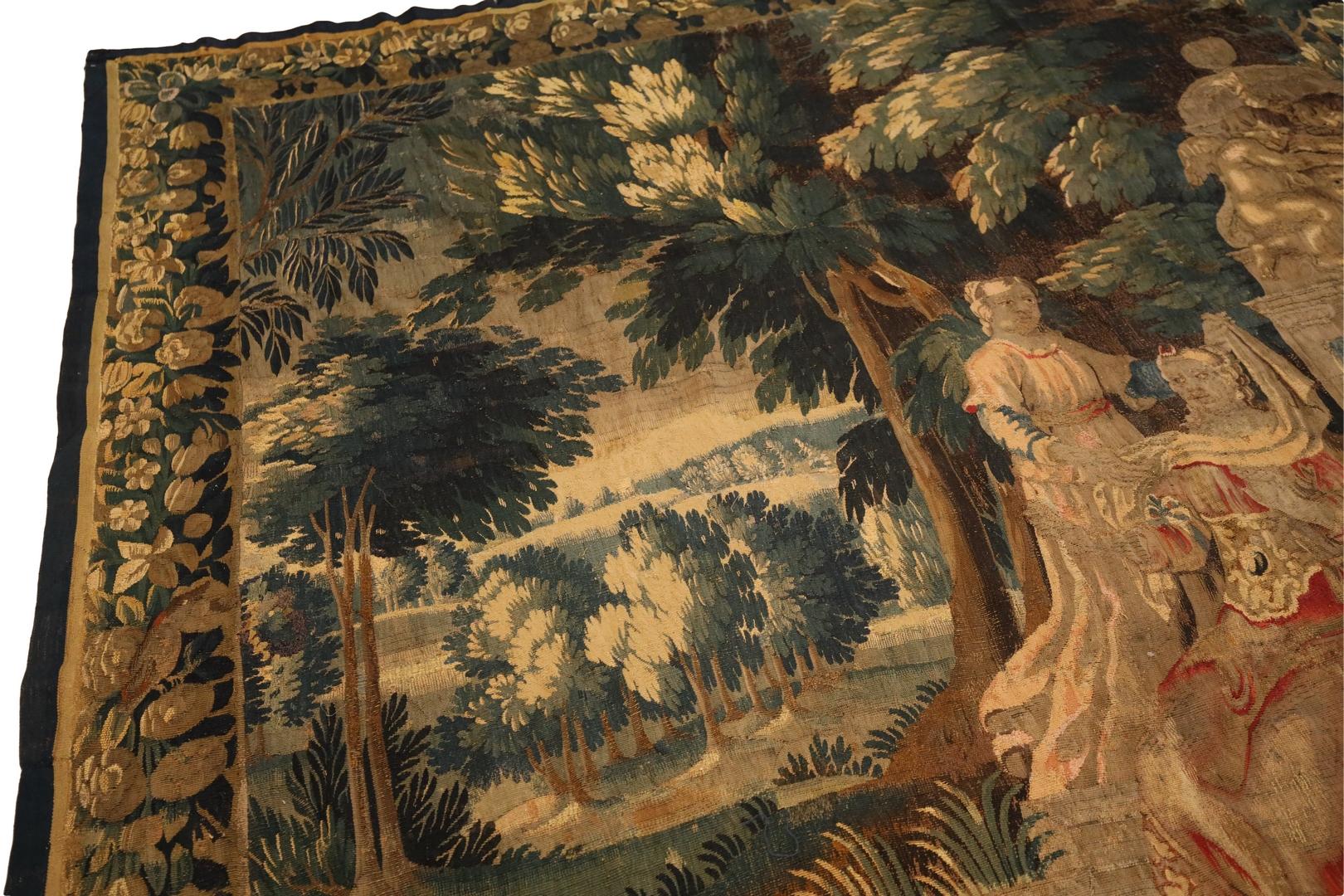 Introducing a masterpiece of French tapestry from the 18th century, a truly remarkable work of art that is both valuable and visually striking. This tapestry depicts a serene scene of a mother and daughter sitting by a fountain in a forest of sorts,