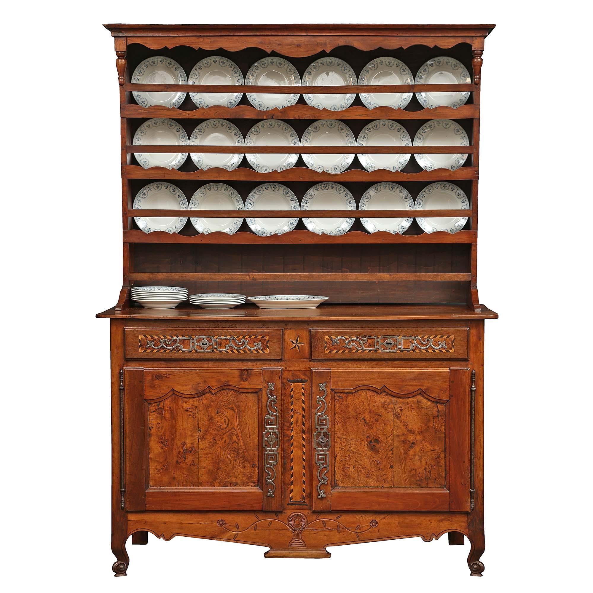 An elegant country French 18th century walnut Vaissellier.The buffet is raised on richly carved cabriole legs, and a finely carved apron with a design of a central urn with scrolled branches, leaves and flowers. Above are two doors with a moulded